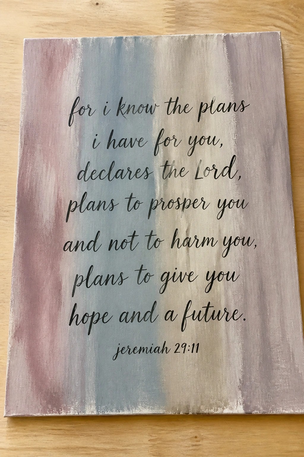 Painted canvas with Jeremiah 29:11 verse in black script on pink-blue background