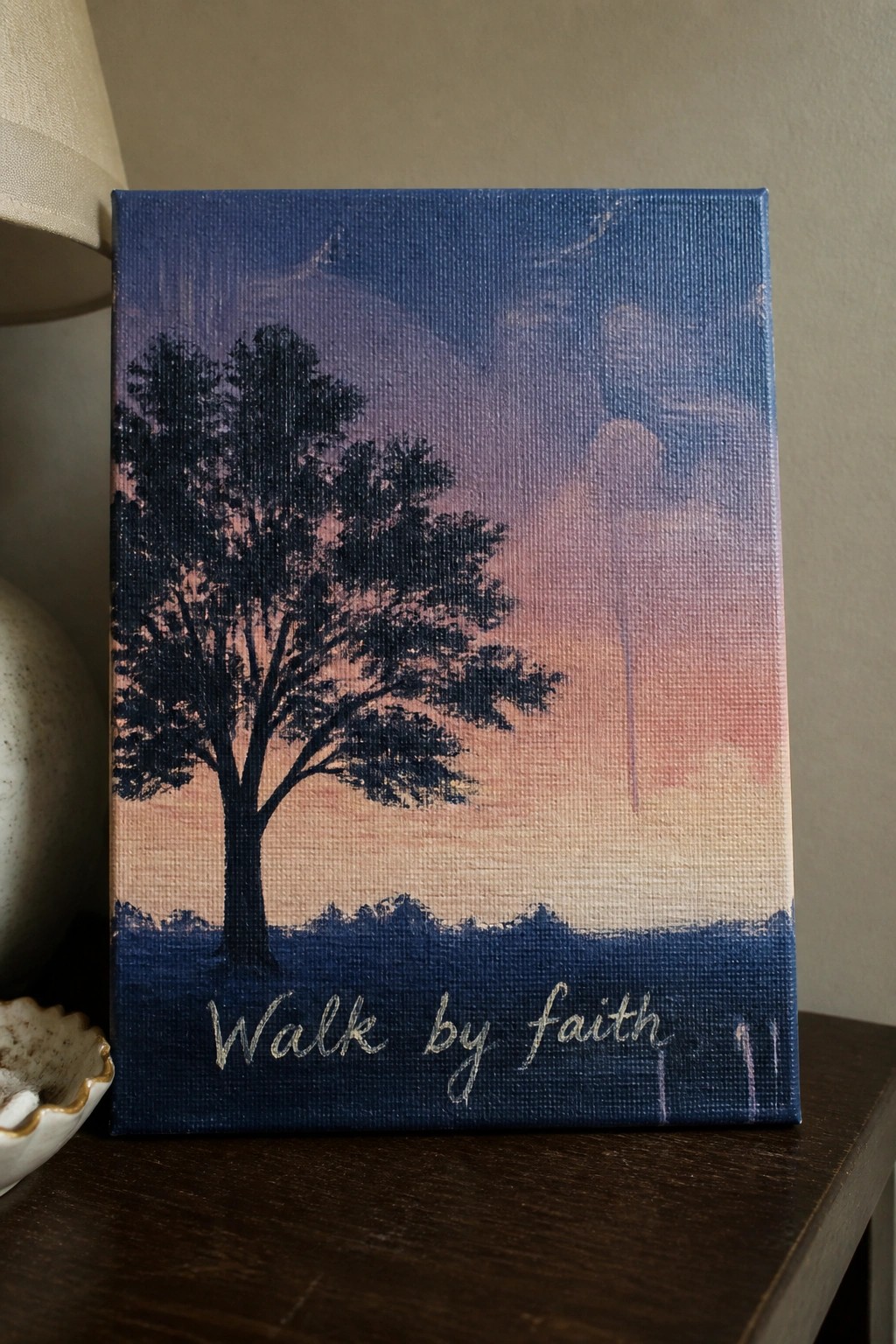 Canvas painting of tree silhouette, sunset sky, cross, and 