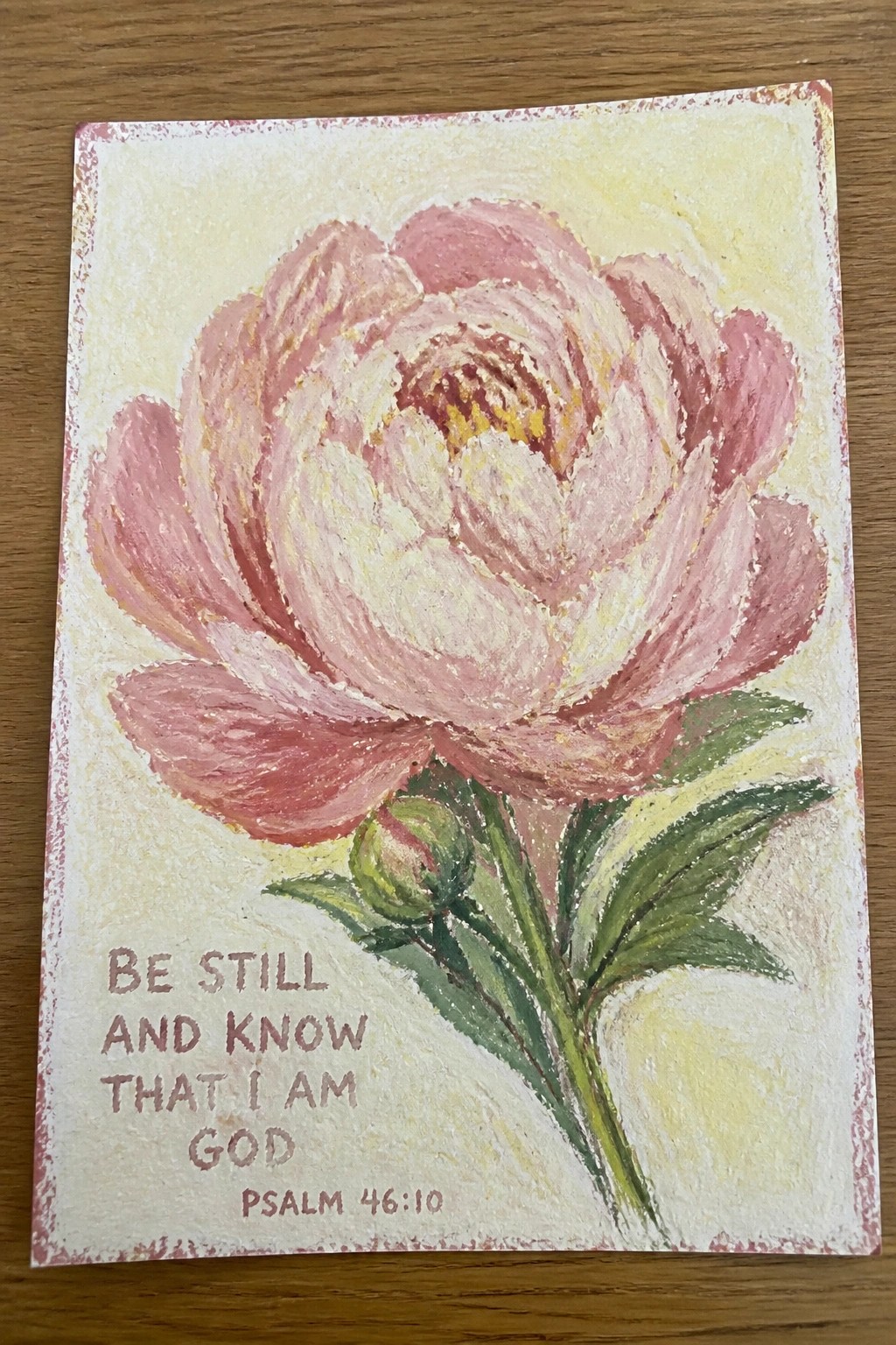 Pink peony flower painting with Bible verse Psalm 46:10 on yellow background.