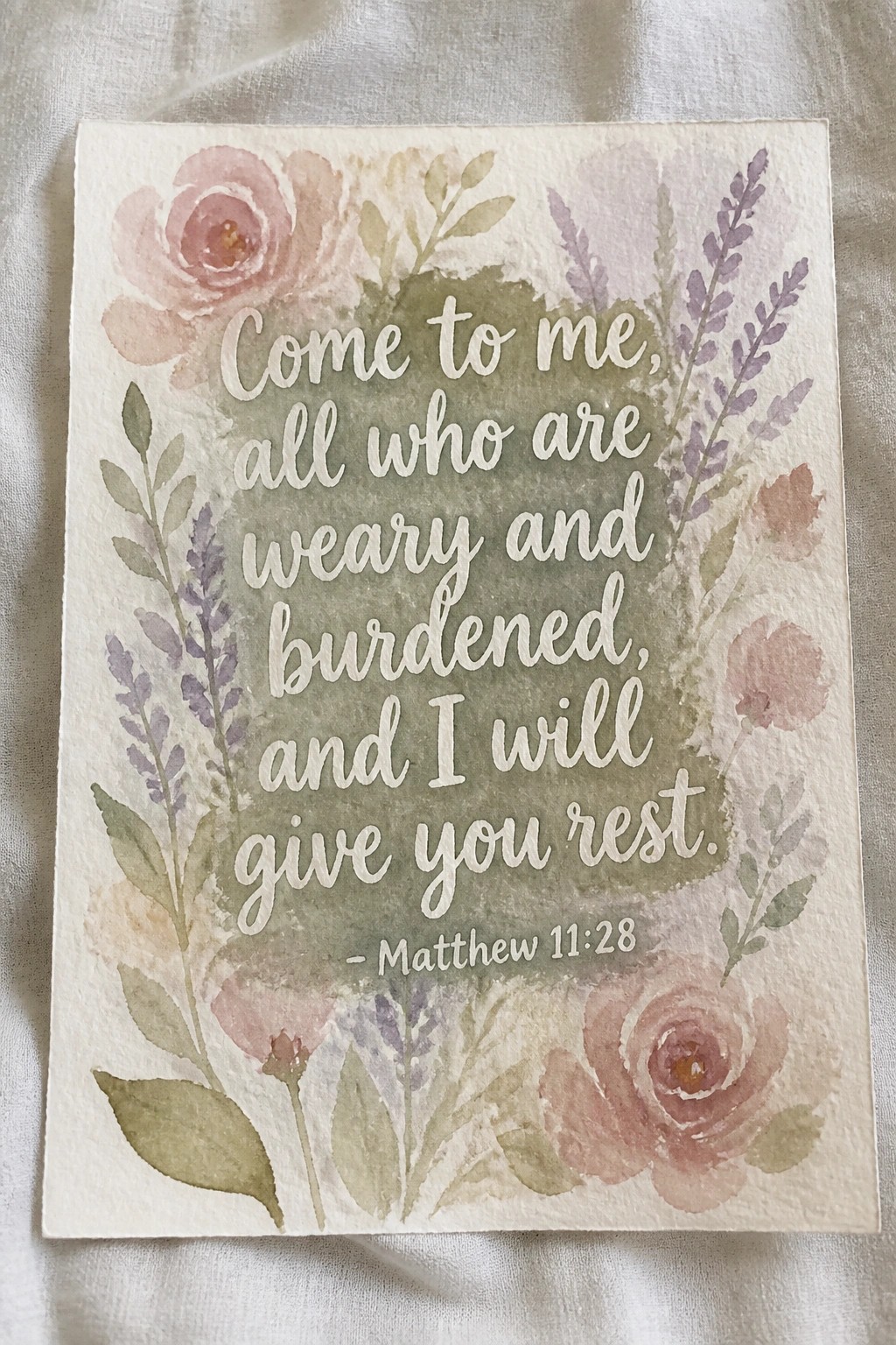Watercolor floral artwork with Matthew 11:28 verse amid pink roses and purple blooms.