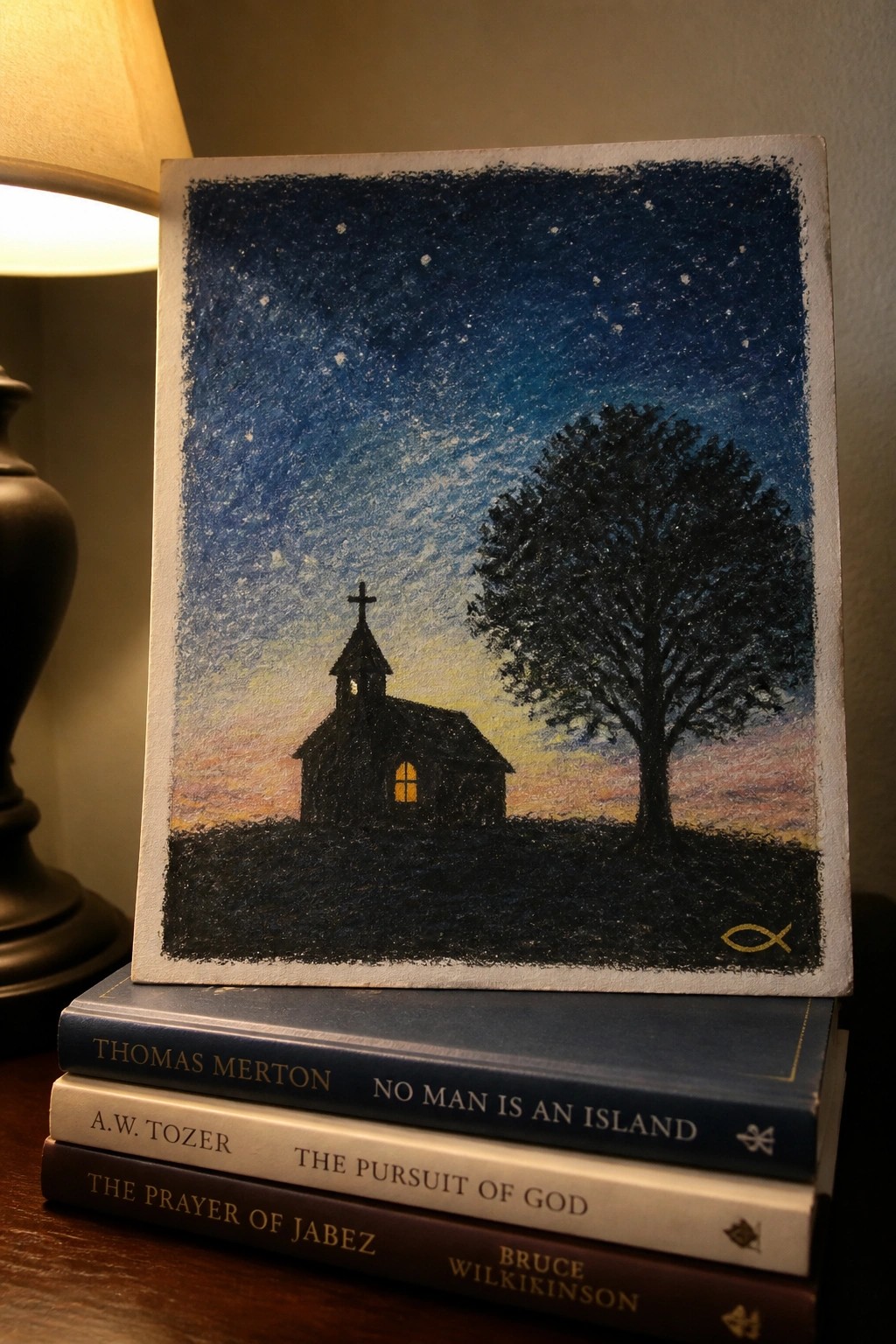 Painting of church and tree under starry sky atop three religious books