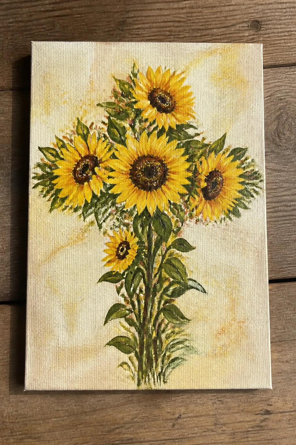 Vibrant yellow sunflowers with green leaves and stems on canvas painting.