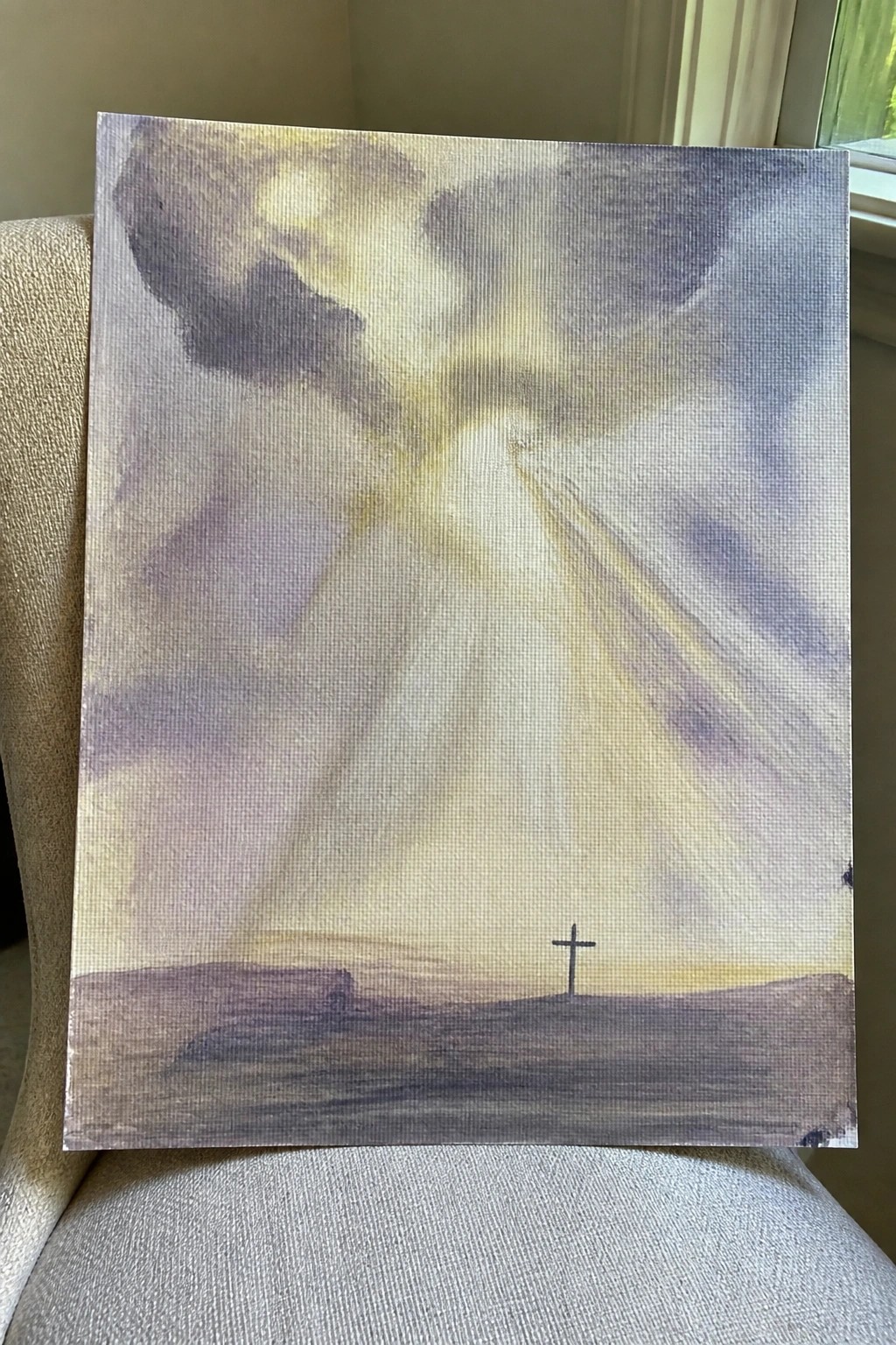 Painting of radiant light beams descending on a cross atop a barren hill under stormy clouds.