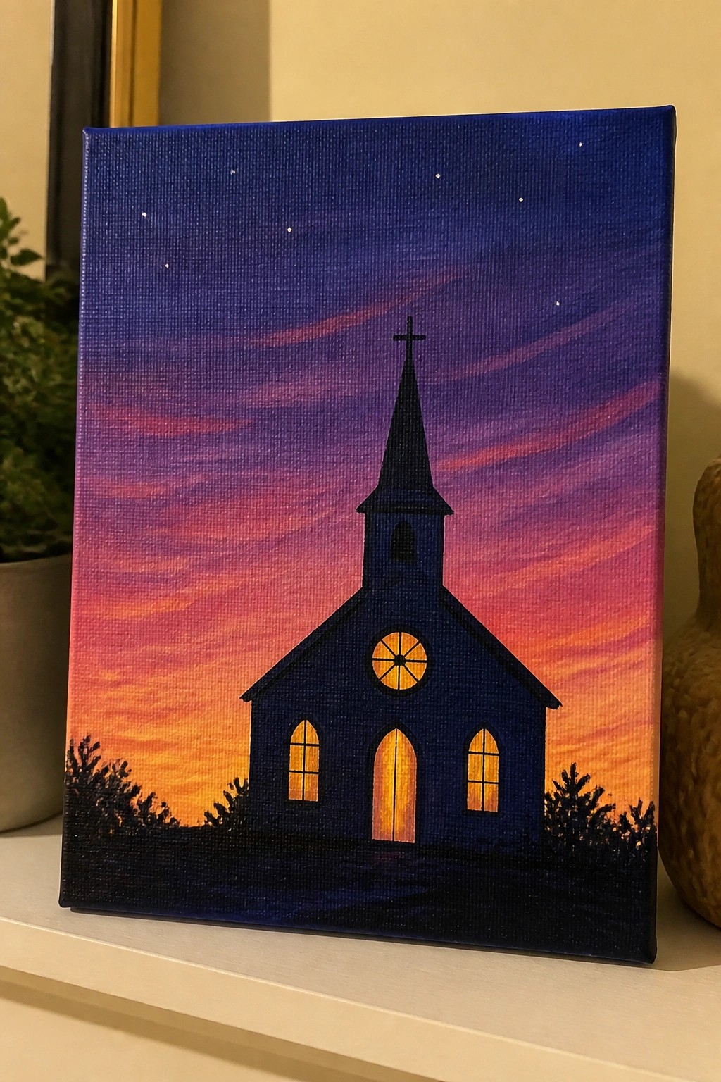 Canvas painting of church silhouette with glowing windows under purple-orange sunset sky