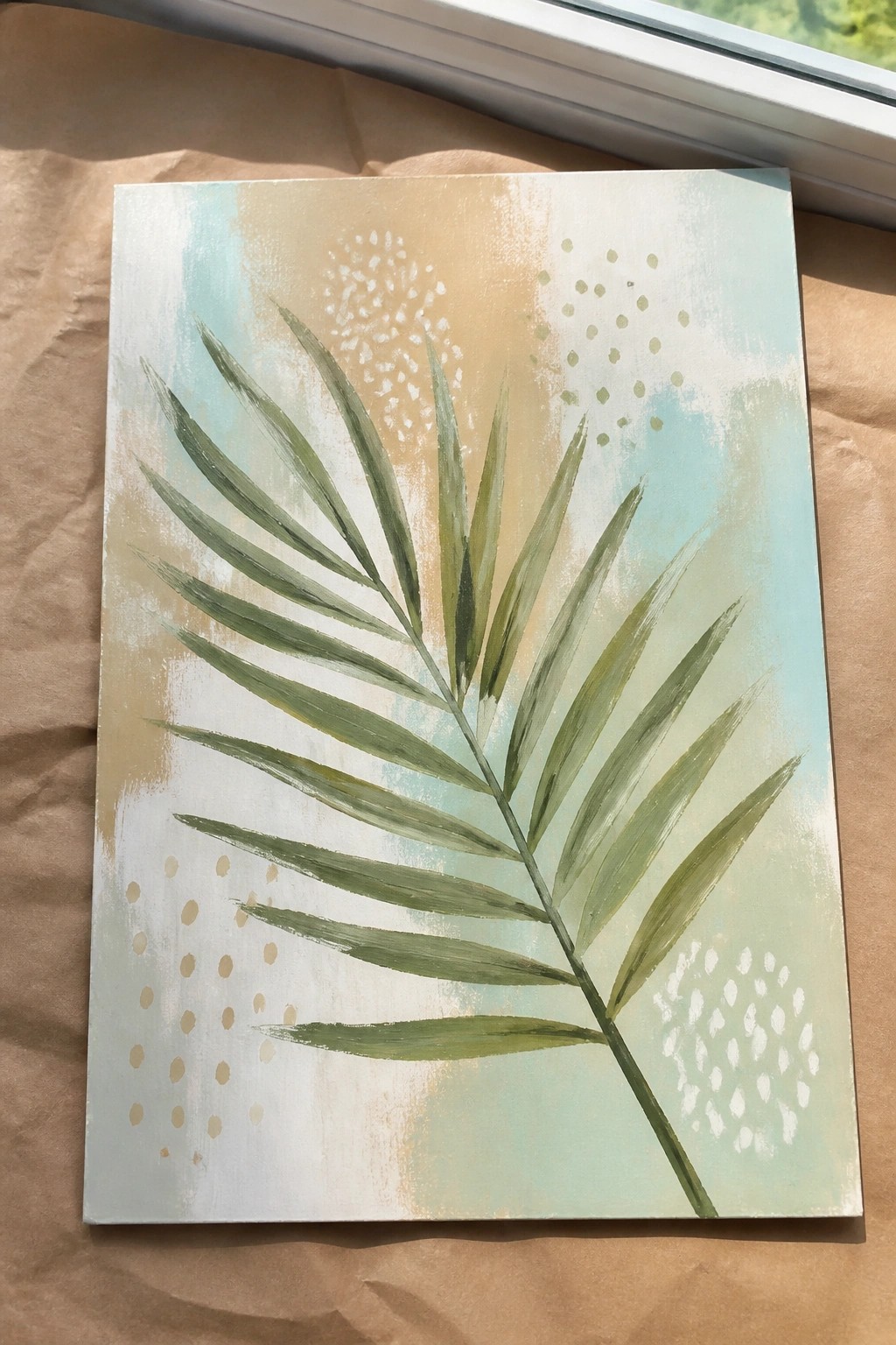 Green palm leaf painting on canvas with abstract pastel blue, beige, and dotted background.