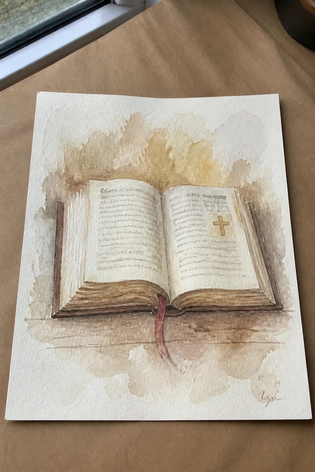 Watercolor painting of open book with golden cross, red bookmark on brown surface