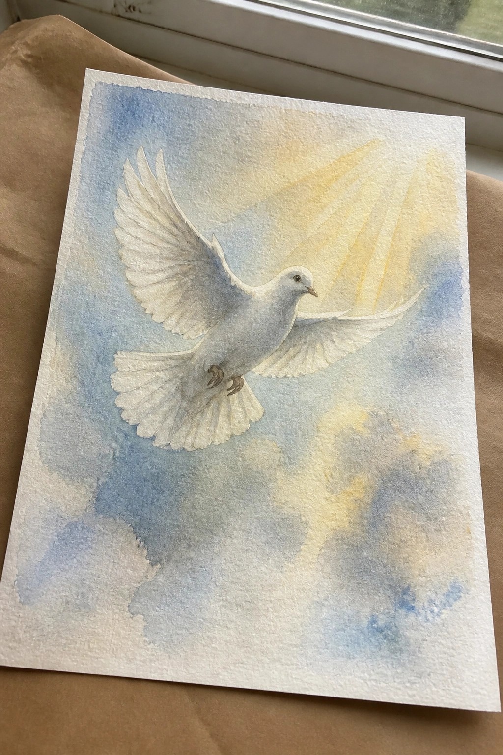 Watercolor painting of white dove flying through blue sky with yellow light rays