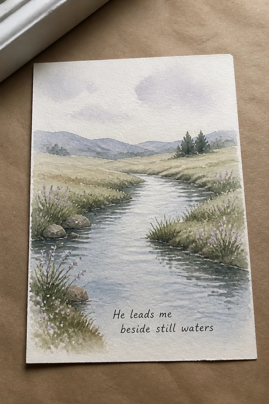 Watercolor of winding stream through grassy hills with purple flowers, rocks, distant mountains, and text.
