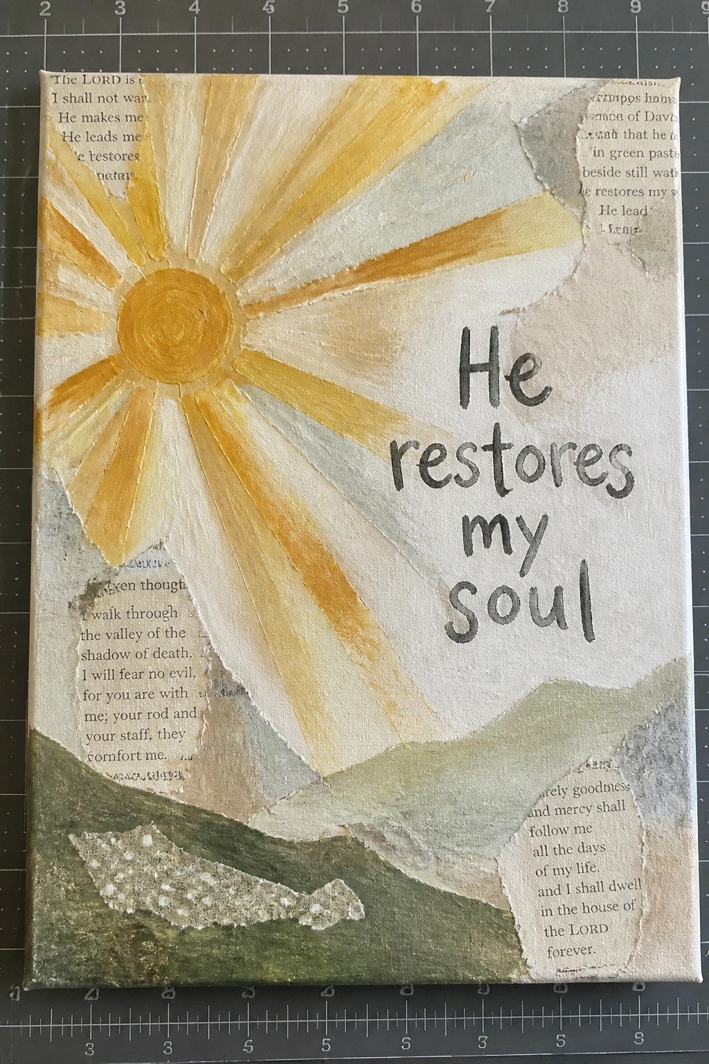 Mixed-media collage with yellow sunburst, green hills, and 
