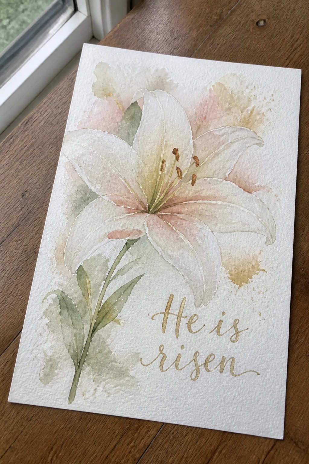 Watercolor white lily with pink and green tones beside gold 