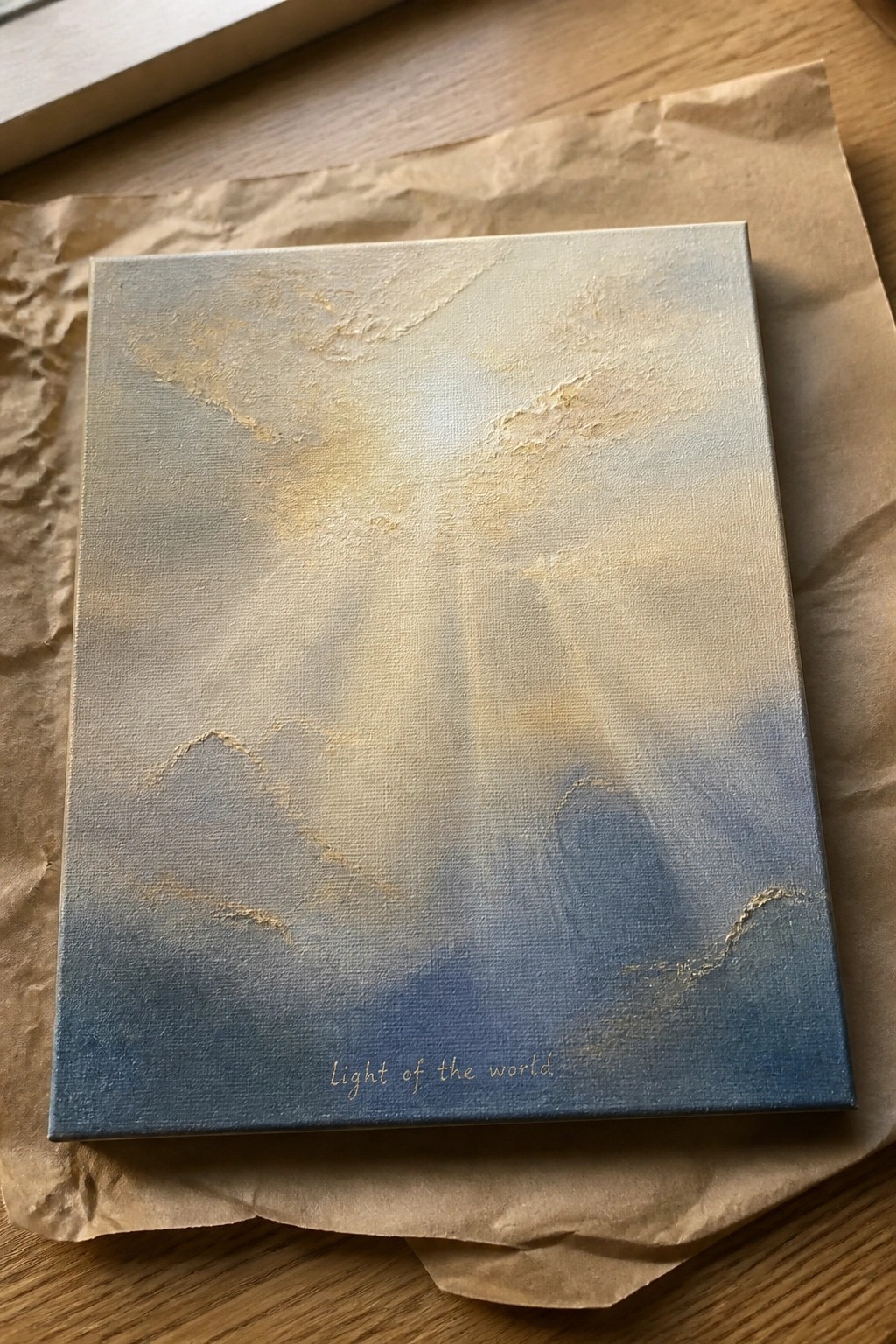 Abstract canvas with golden light rays through blue clouds and text on brown paper