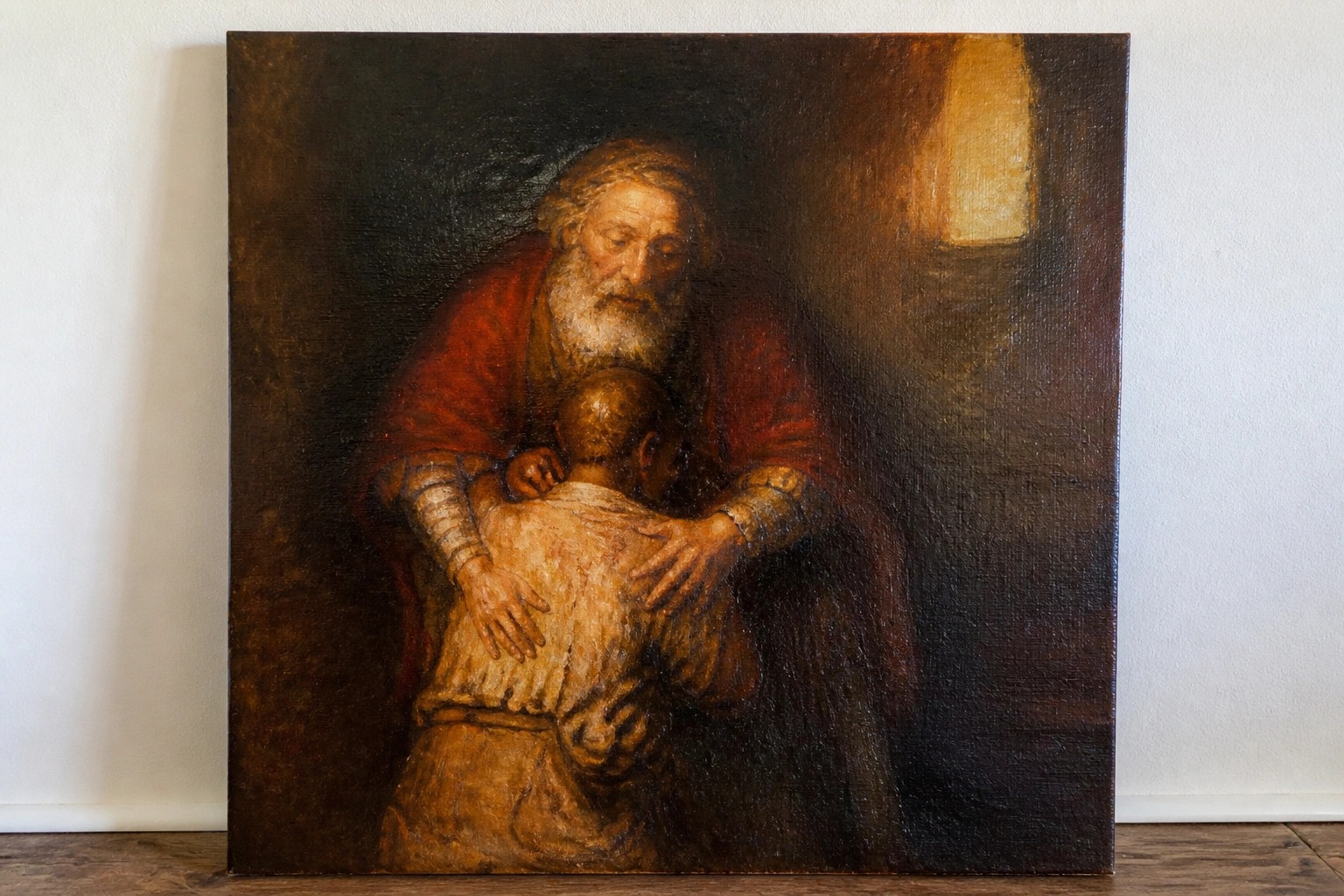 Elderly bearded man in red cloak embraces kneeling ragged youth, another observes.