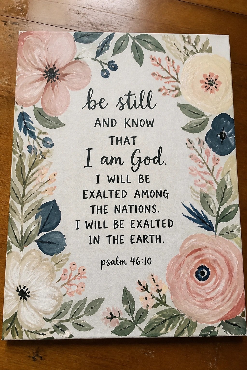 Floral canvas painting with pink blue flowers and Psalm 46:10 verse text.