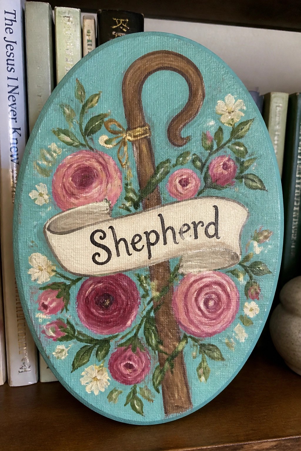 Turquoise oval plaque with shepherd's crook, pink roses, and white 