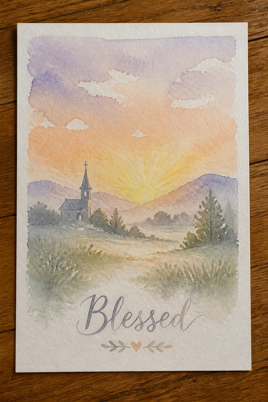 Watercolor sunset landscape with church, mountains, glowing sun, and Blessed text below
