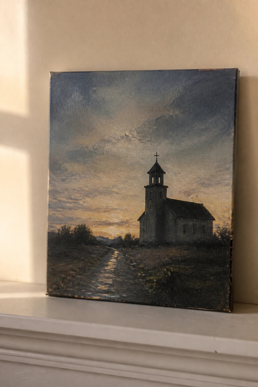 Oil painting of silhouetted church with steeple, path at golden sunset on white ledge.