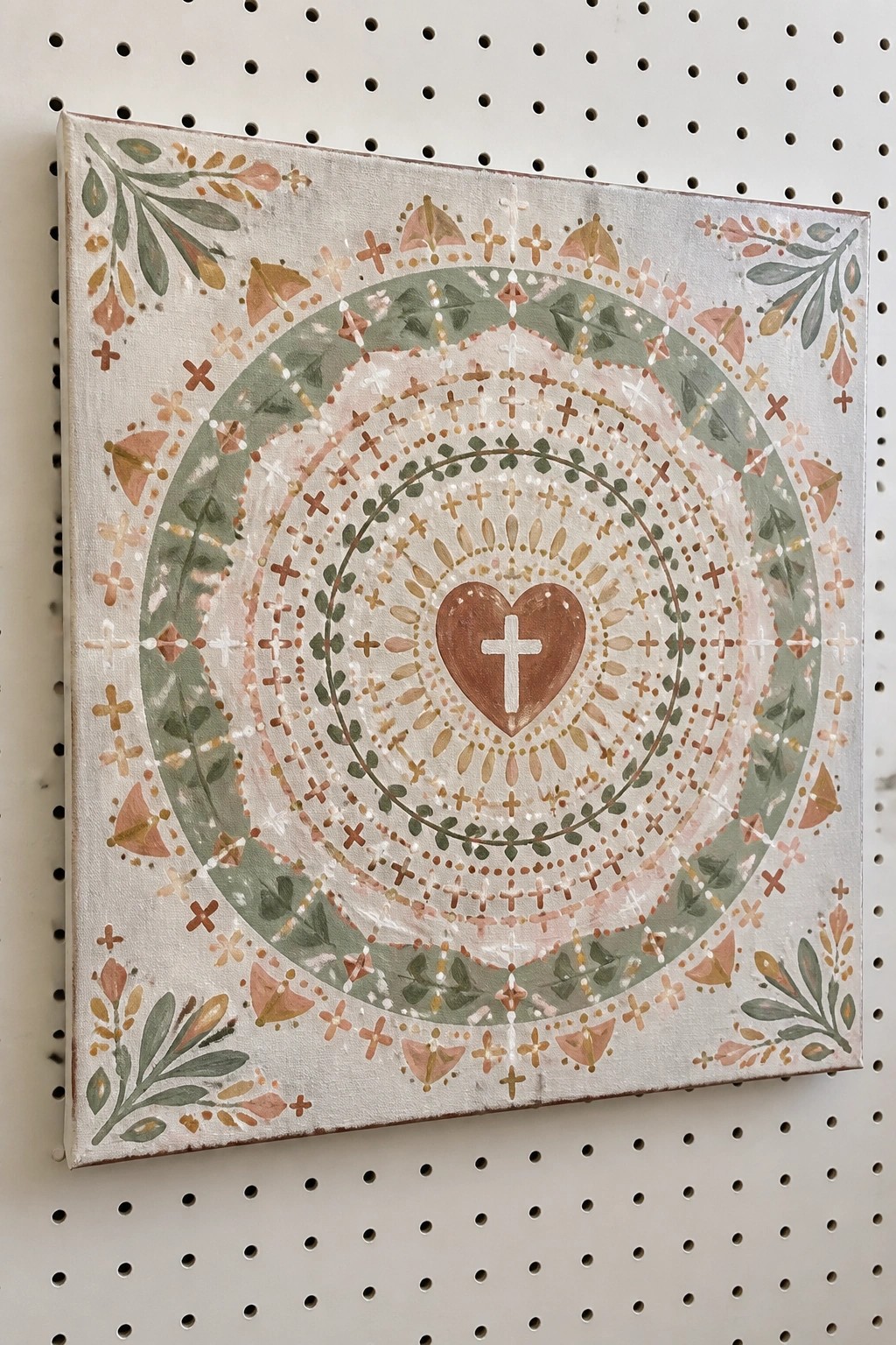 Earth-toned mandala on square canvas with central heart and cross motif