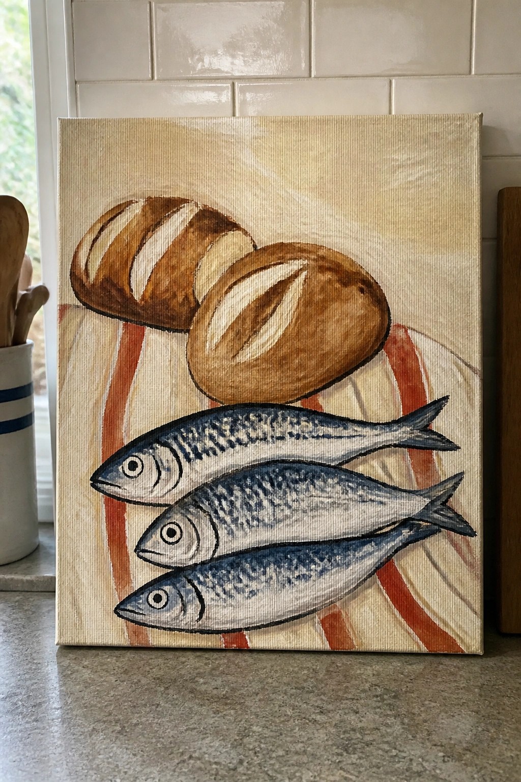 Acrylic painting of two brown bread loaves above three blue fish on striped cloth