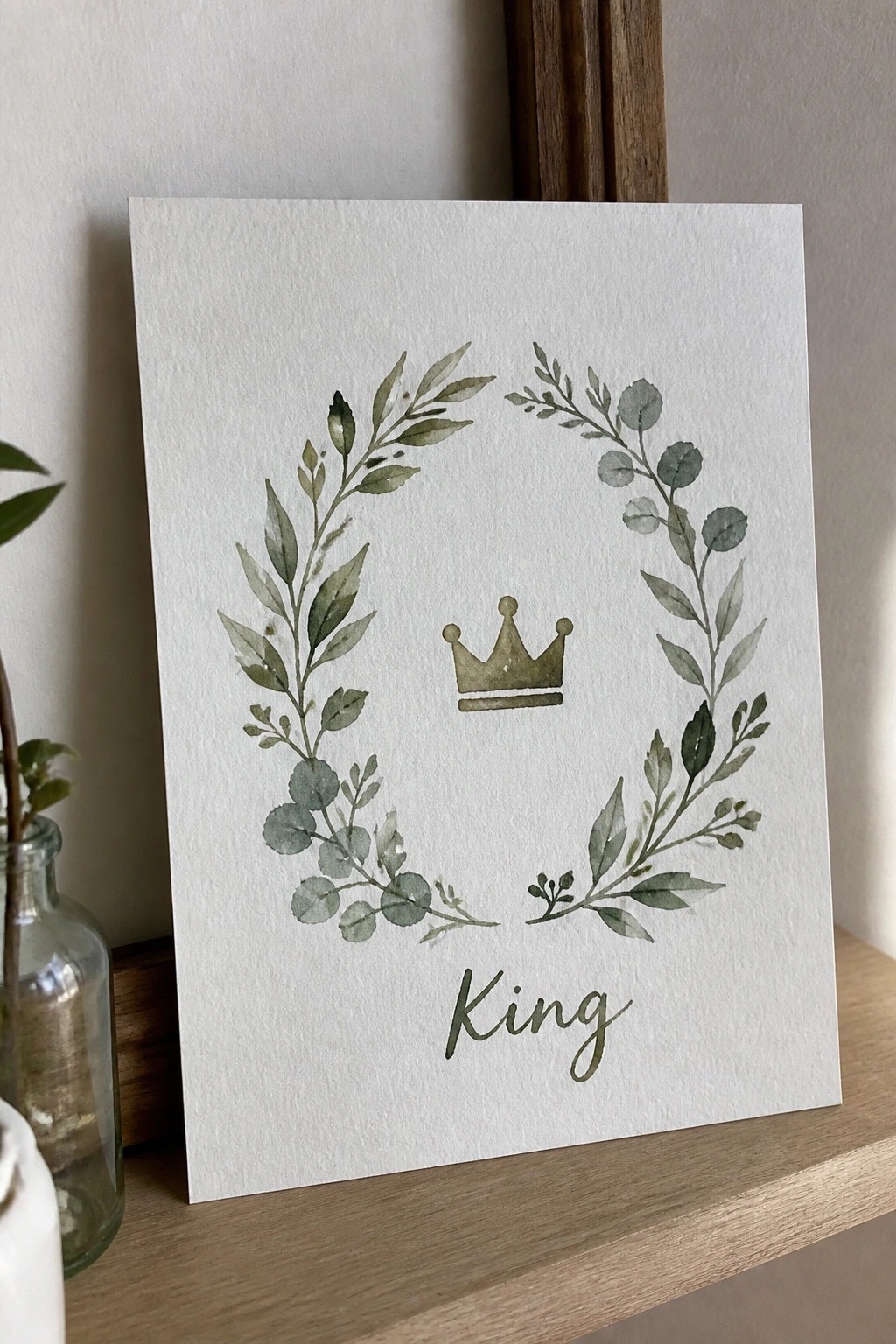 Watercolor green leaf wreath with gold crown above cursive