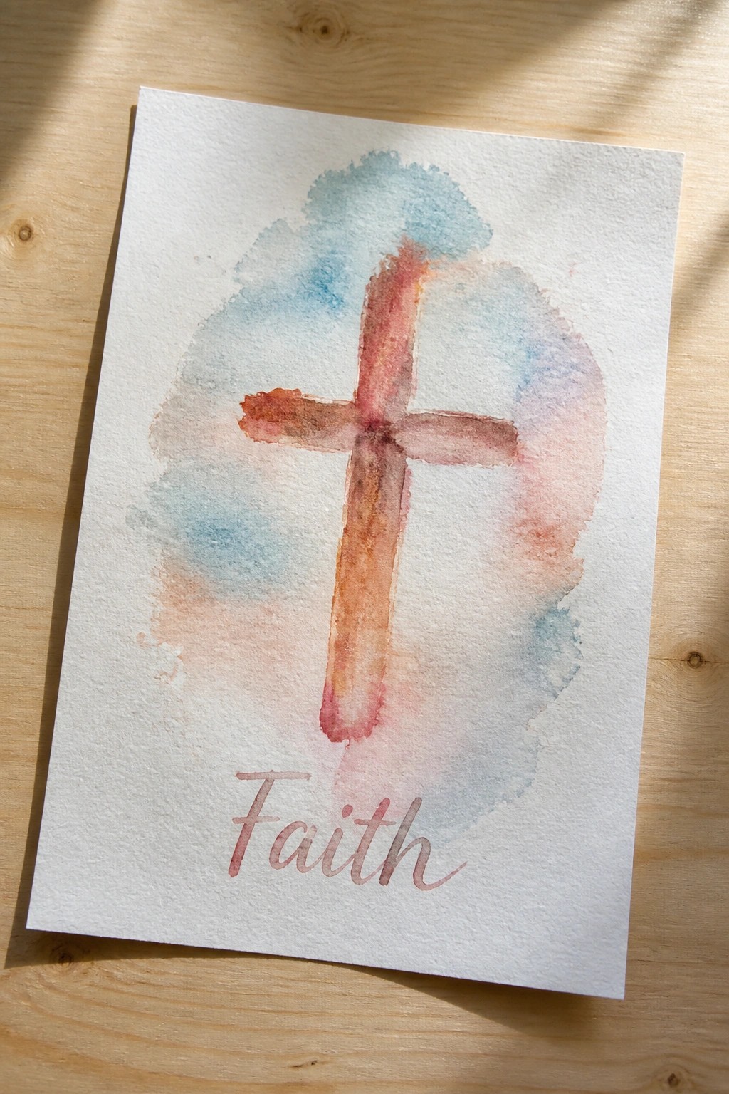 Watercolor cross in warm red-orange tones with blue-pink washes and cursive