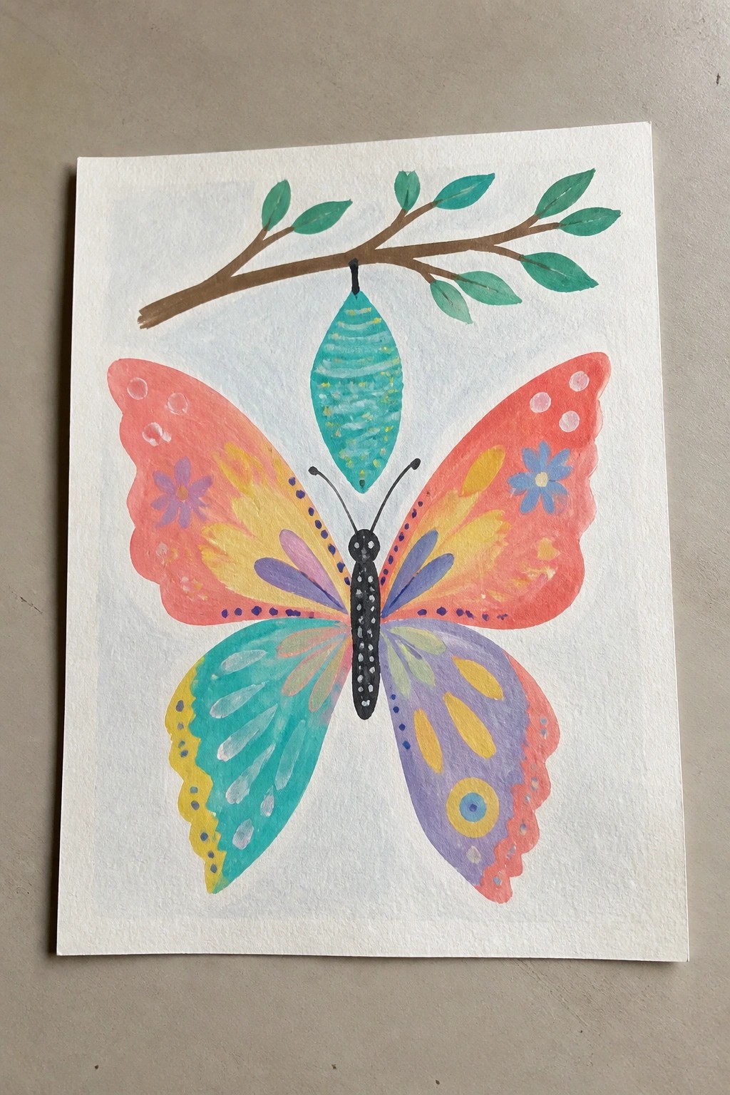 Colorful watercolor butterfly with patterned wings below turquoise chrysalis on leafy branch.