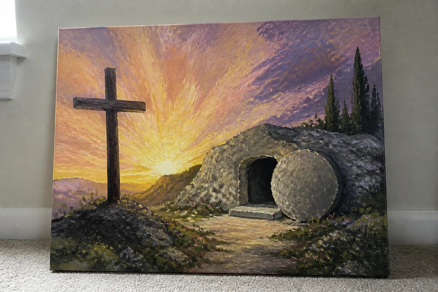 Painting of empty stone tomb with rolled boulder beside wooden cross at vibrant sunrise