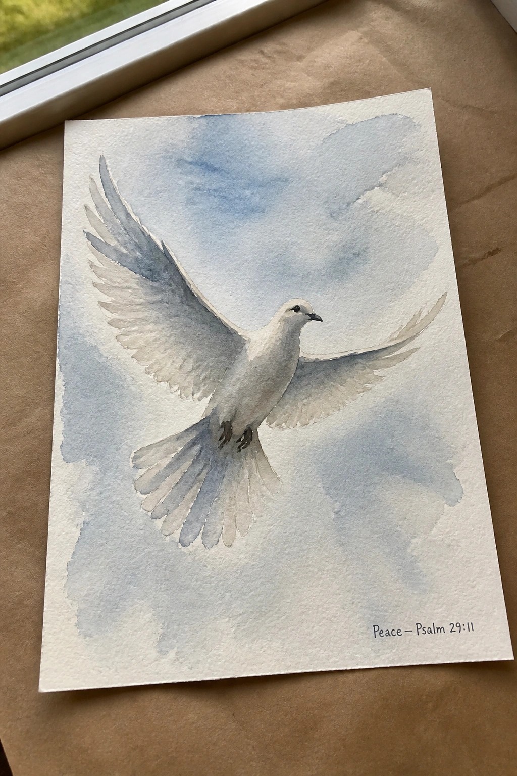 Watercolor of white dove soaring in blue cloudy sky, inscribed Peace Psalm 29:11