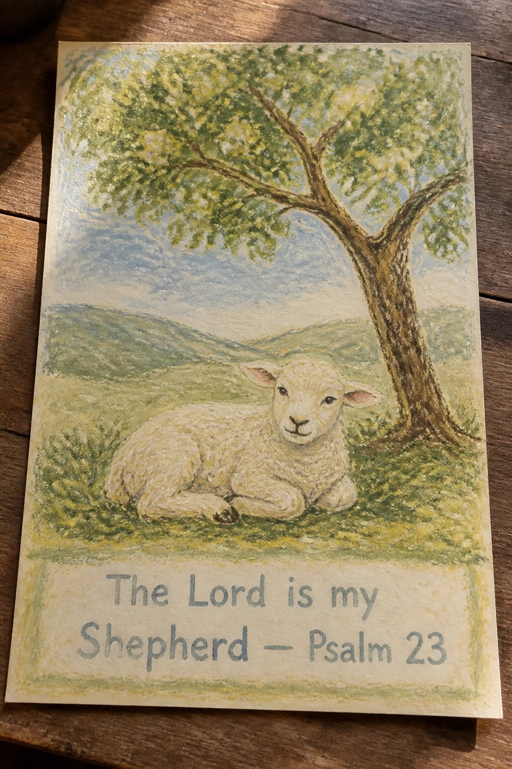 Watercolor of white lamb resting under tree in green hills with Psalm 23 text below