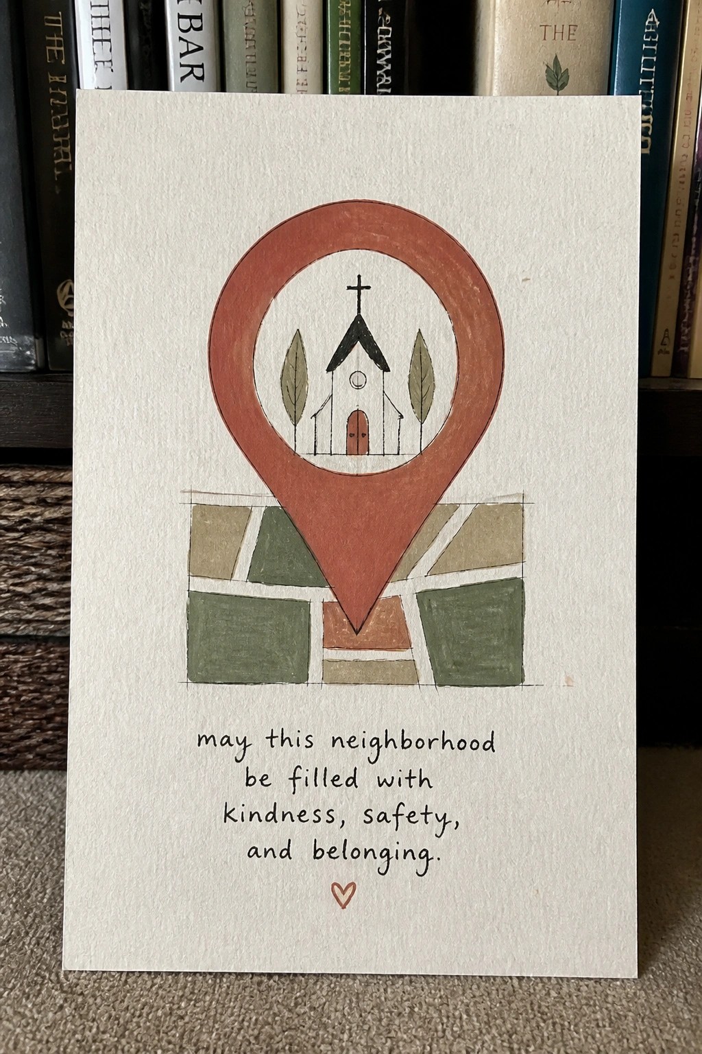 A card shows a red location pin with a church inside it above a patchwork map of green and brown blocks and a short blessing message.