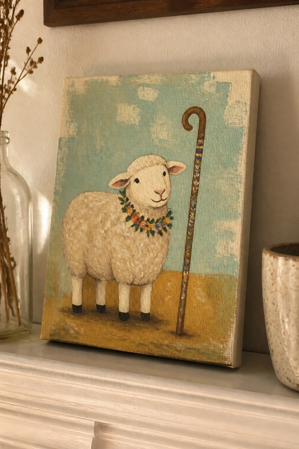 Pastel canvas painting of sheep with floral garland beside shepherd's crook on mantel.