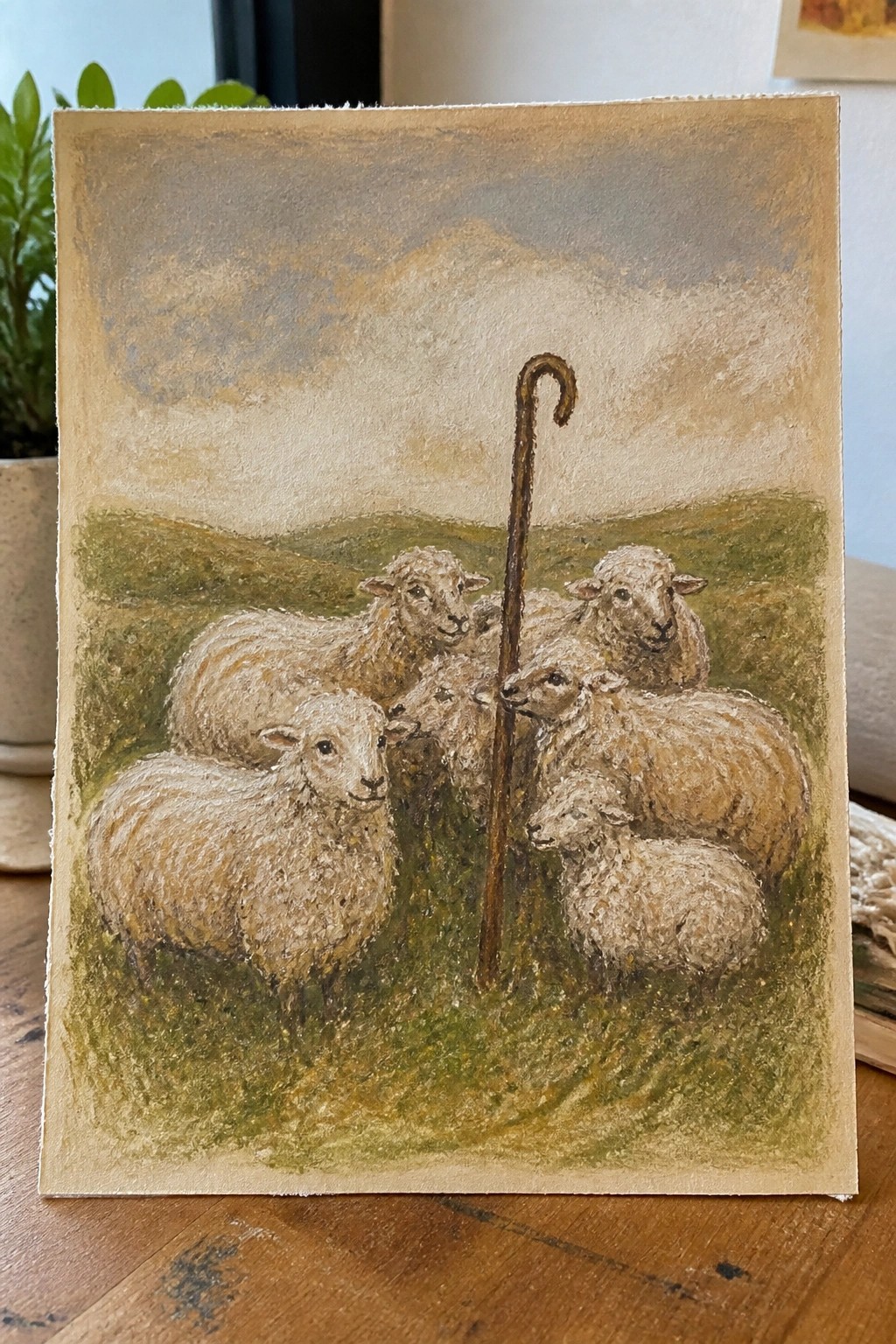 Beige-toned painting of white sheep clustered around a shepherd's crook in grassy hills