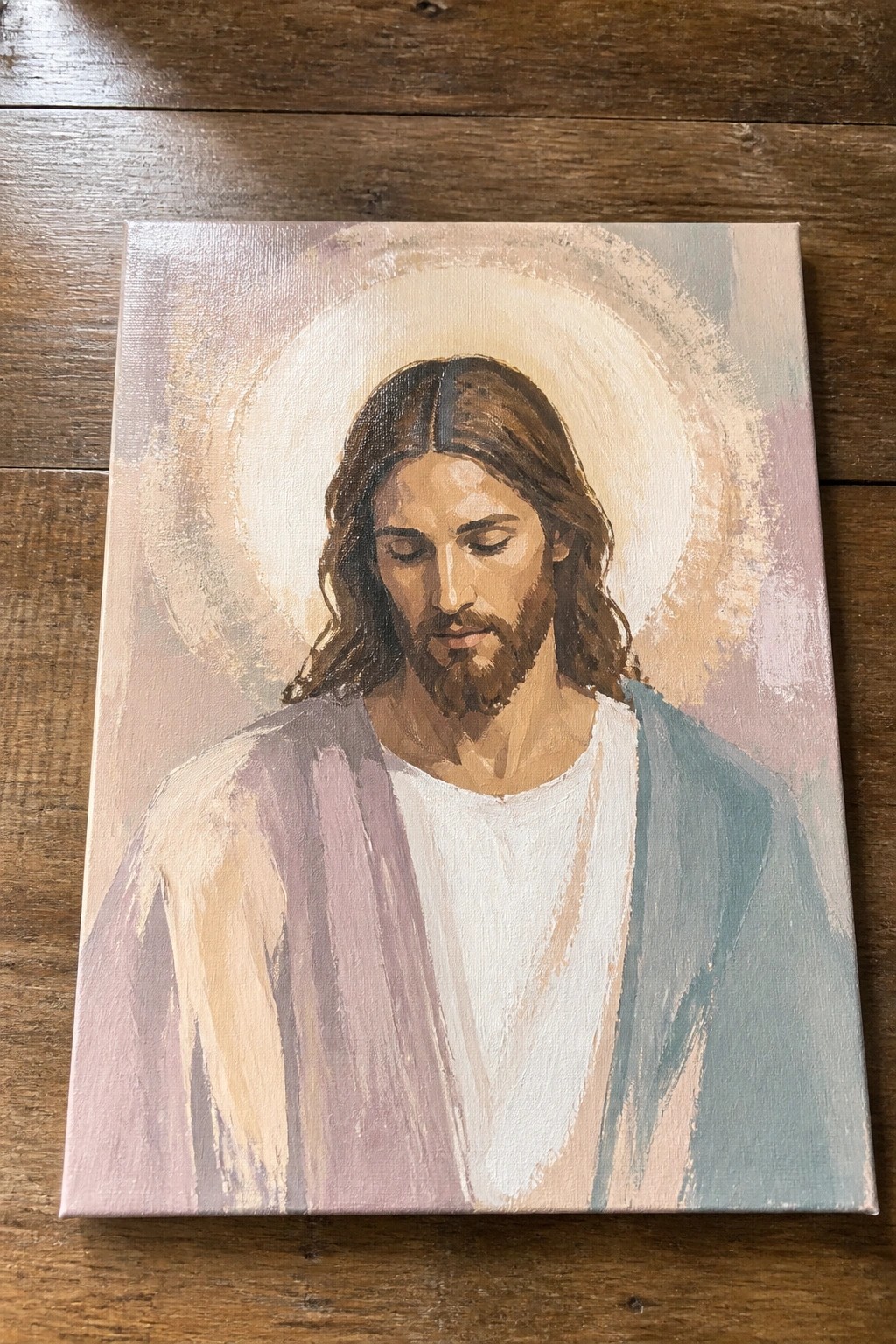 Jesus with halo, long brown hair, beard, closed eyes, purple and blue robes.