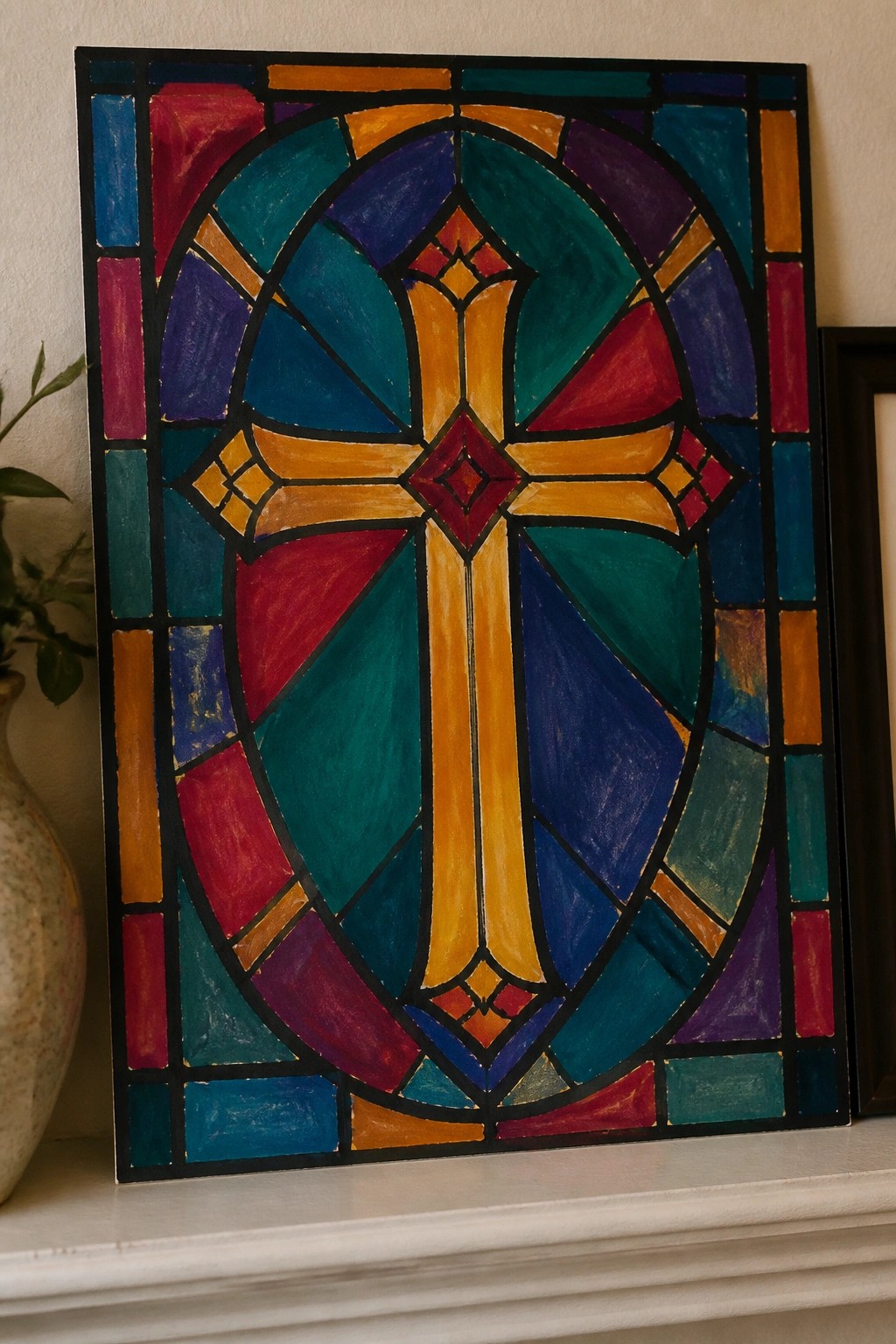Vibrant stained glass artwork with central cross on white mantelpiece.