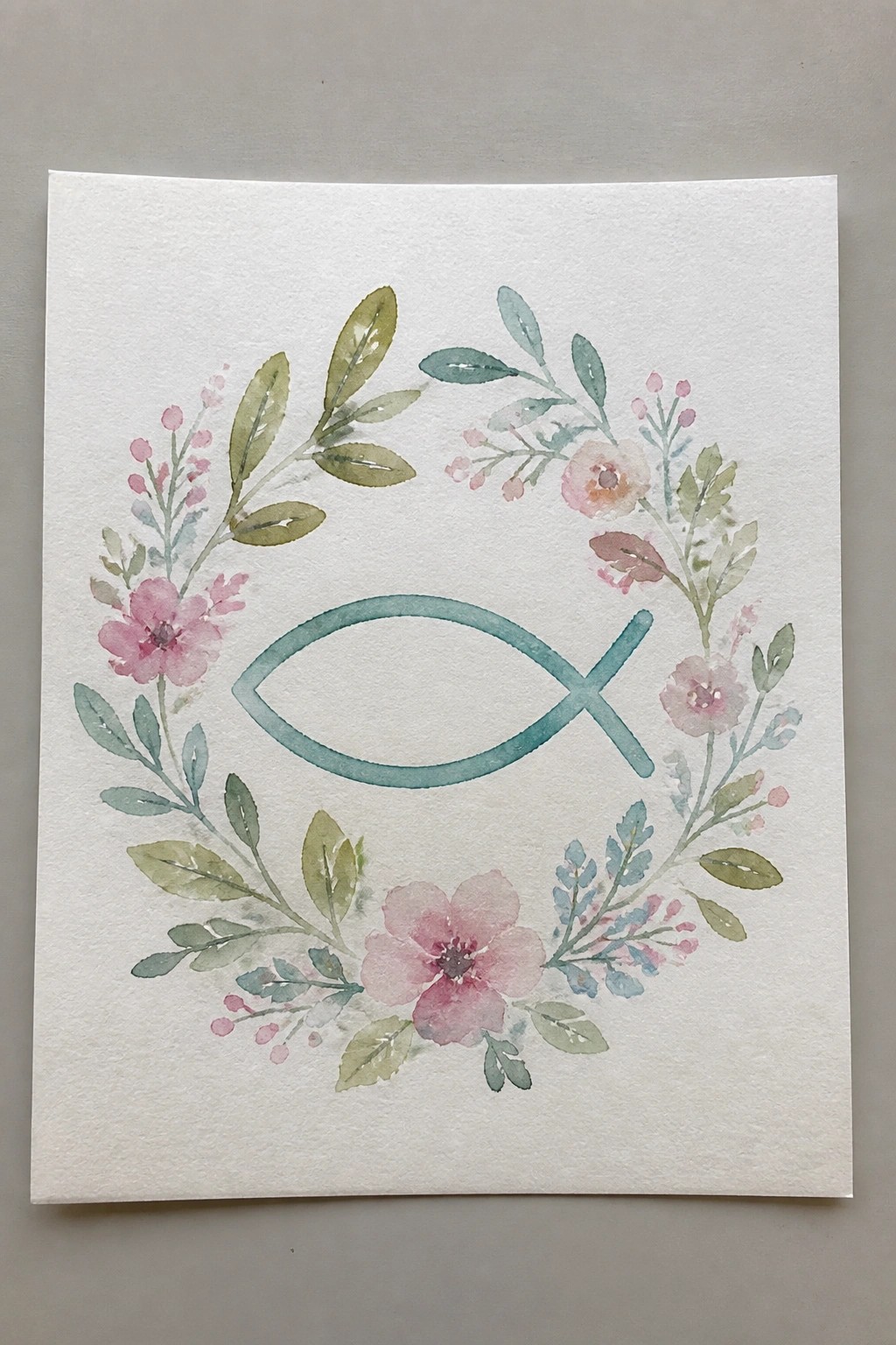 Watercolor wreath of pink flowers and green leaves around a teal fish symbol