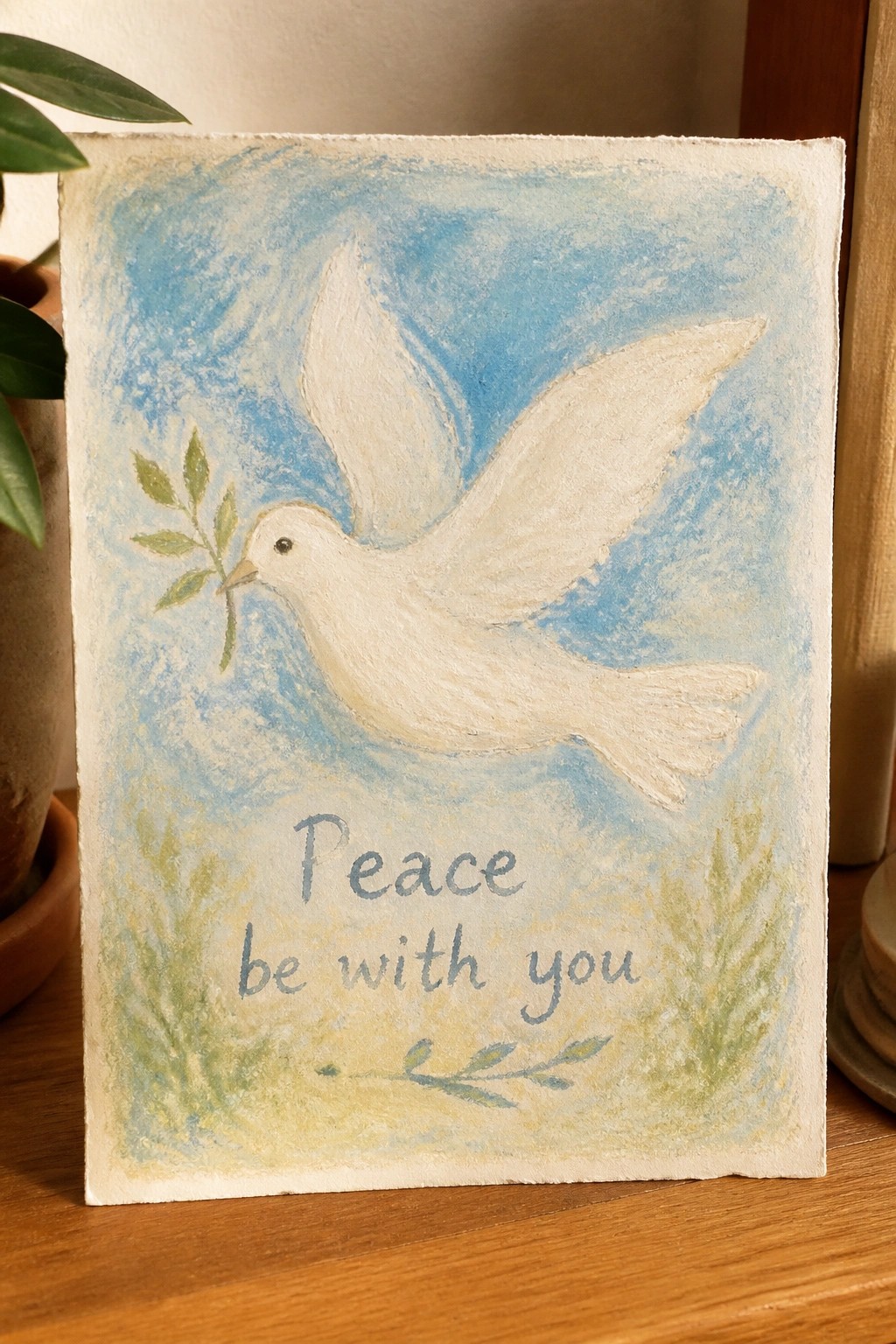 White dove with olive branch in blue sky above 