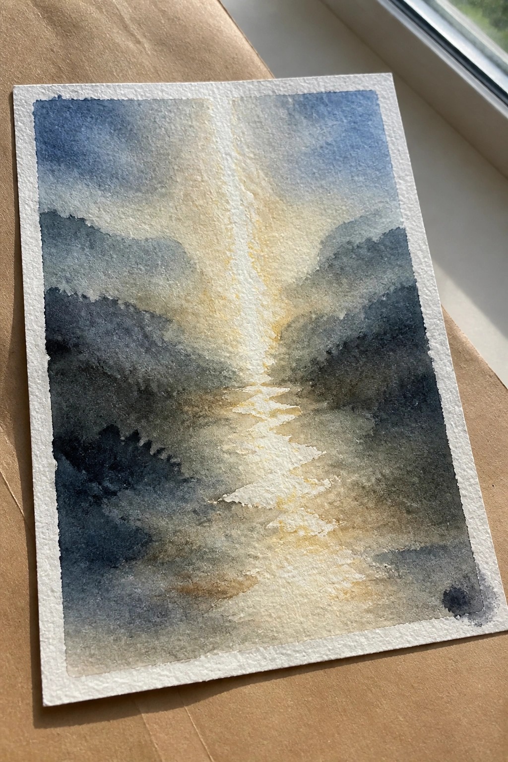 Watercolor landscape of misty blue mountains with a glowing central path