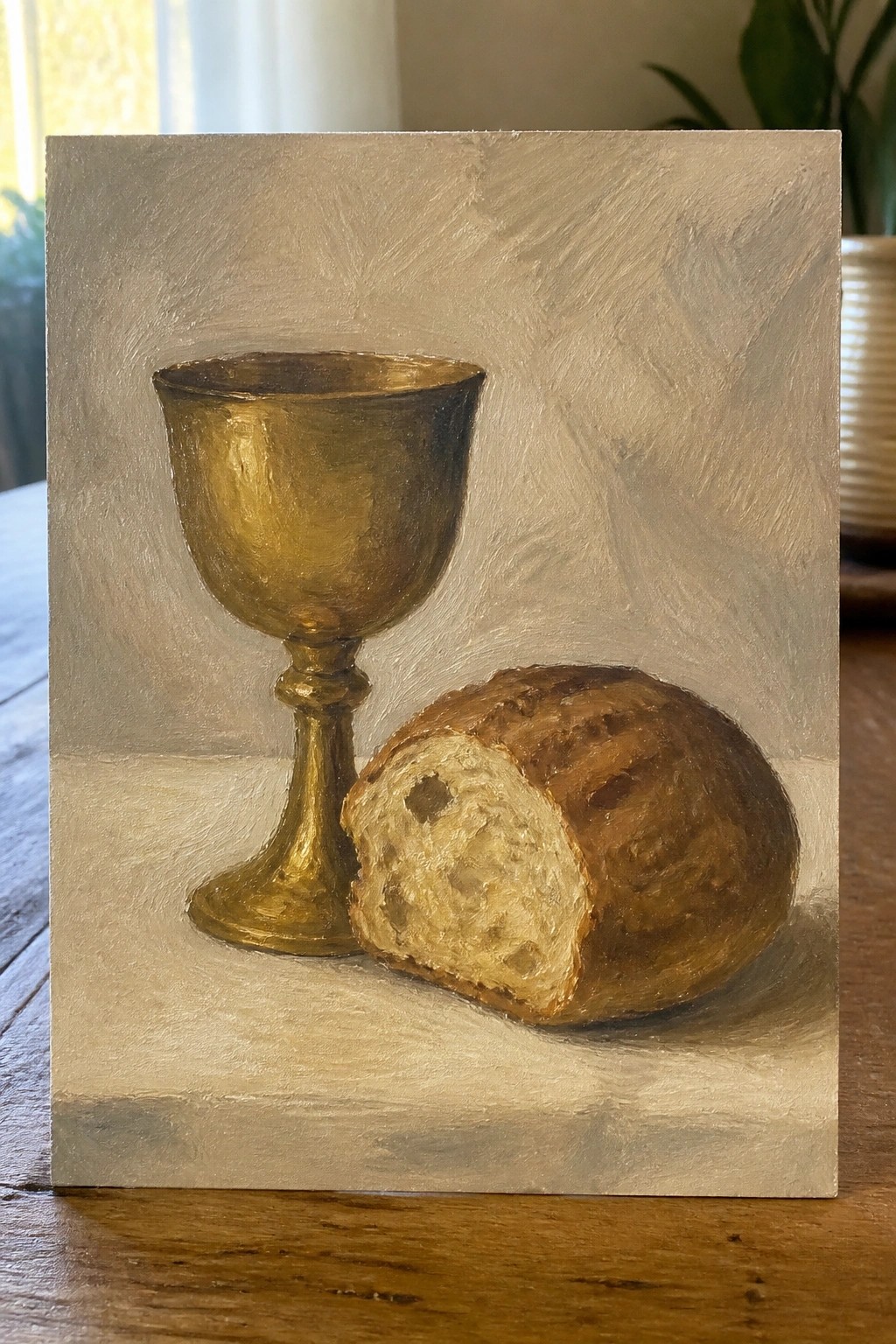 Oil painting of golden chalice beside partially sliced crusty bread loaf