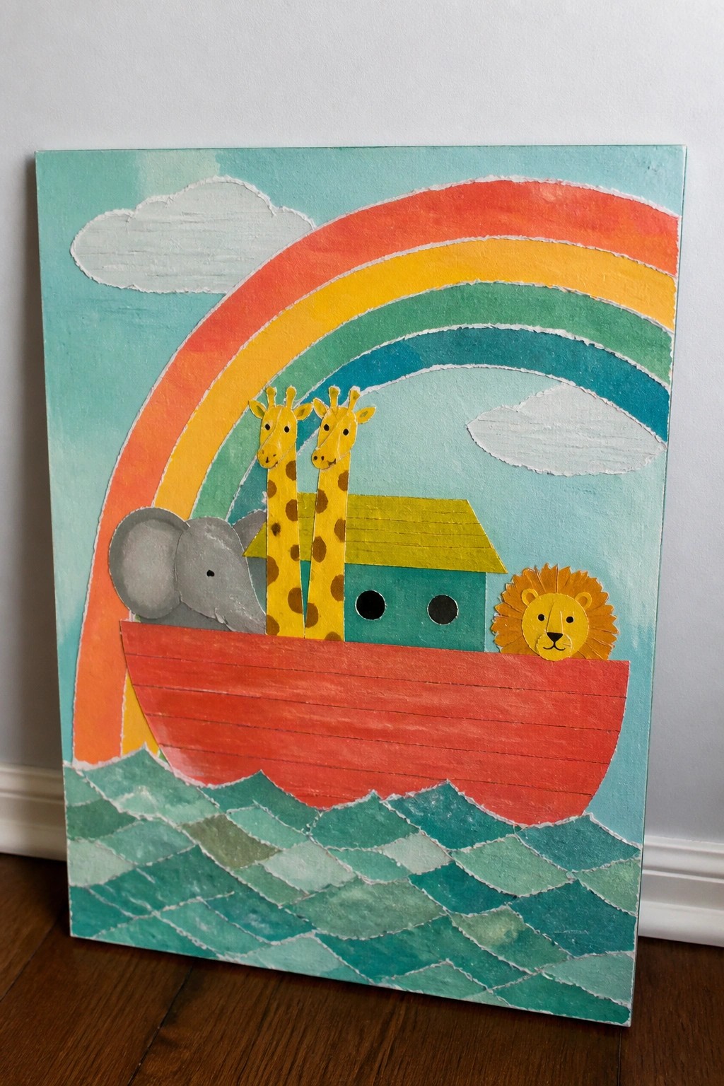 Colorful rainbow over red ark boat with elephant, giraffes, and lion on waves