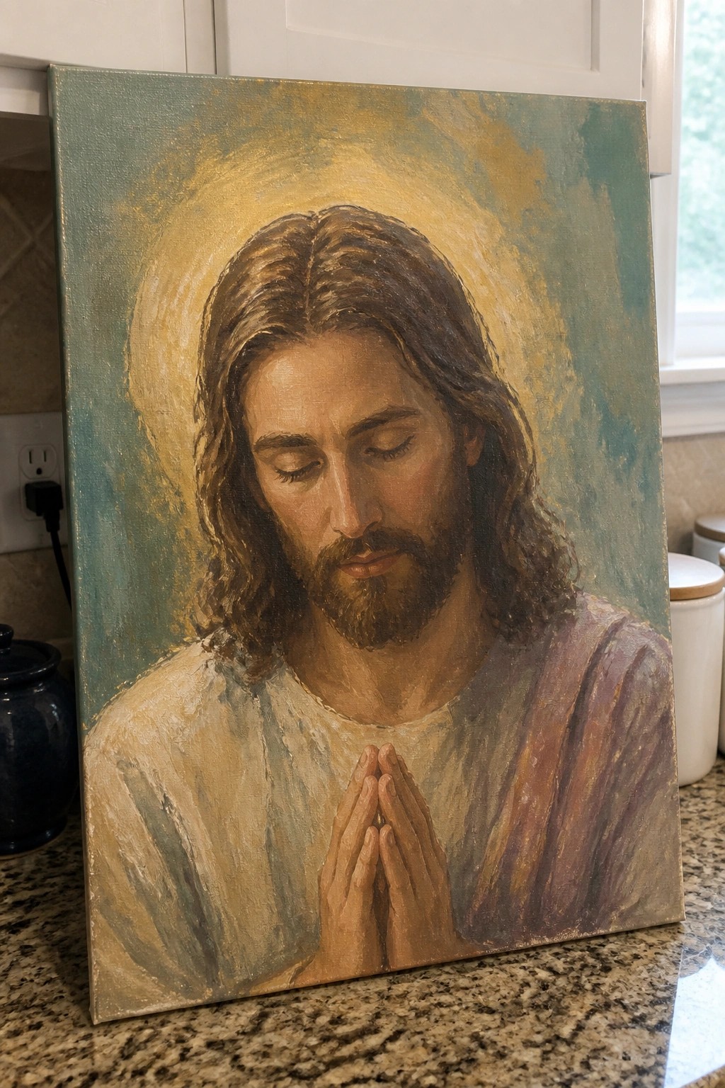 Oil painting of Jesus with closed eyes, clasped hands, and golden halo on kitchen counter