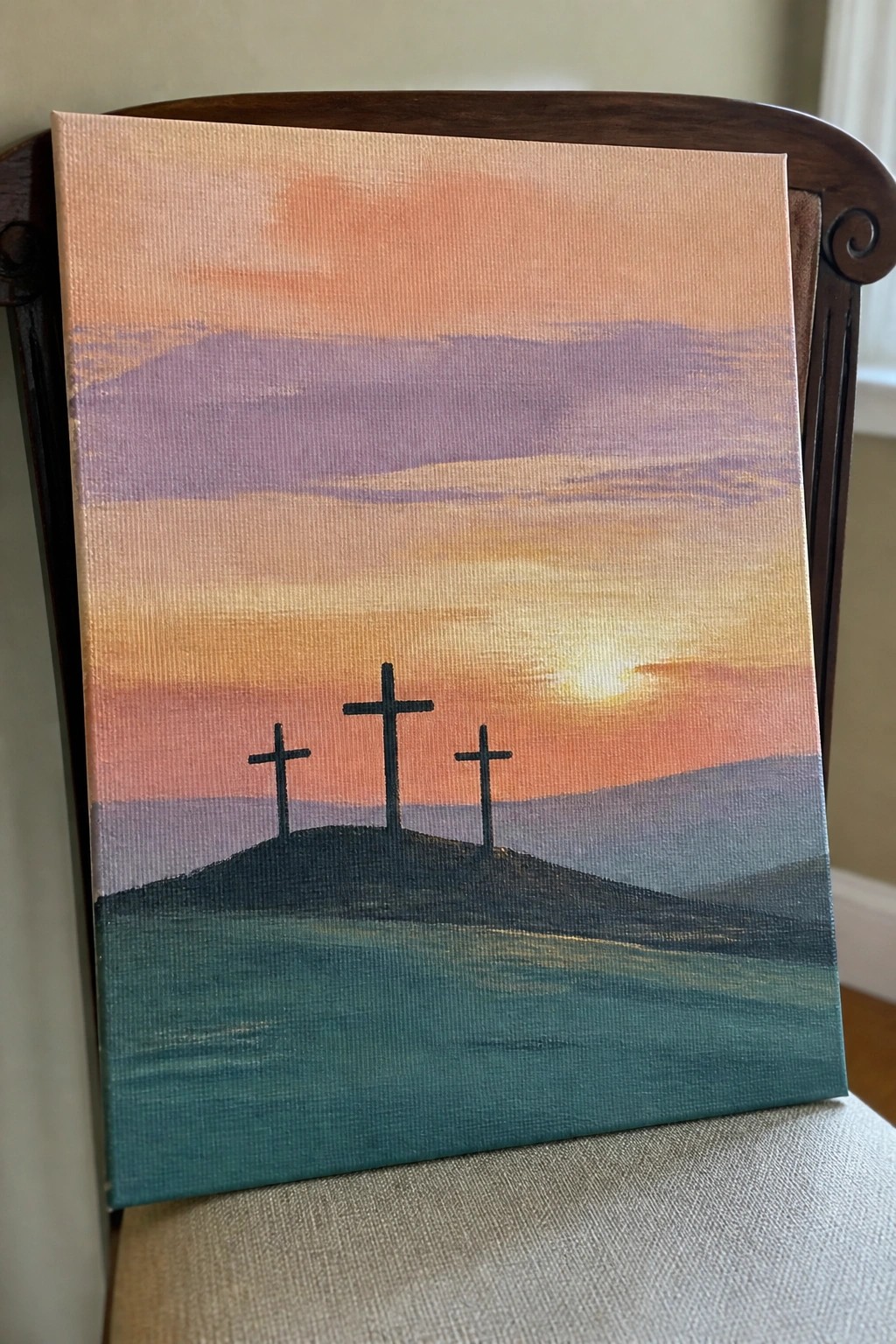 Three crosses on a hill under a vibrant orange-purple sunset sky on canvas.