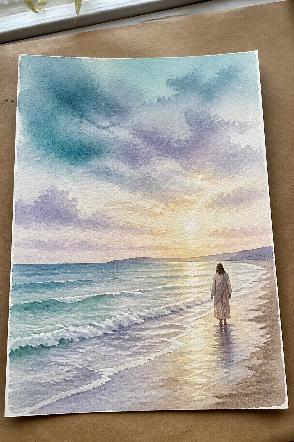 Watercolor of robed figure walking along beach at sunset with waves and colorful sky.