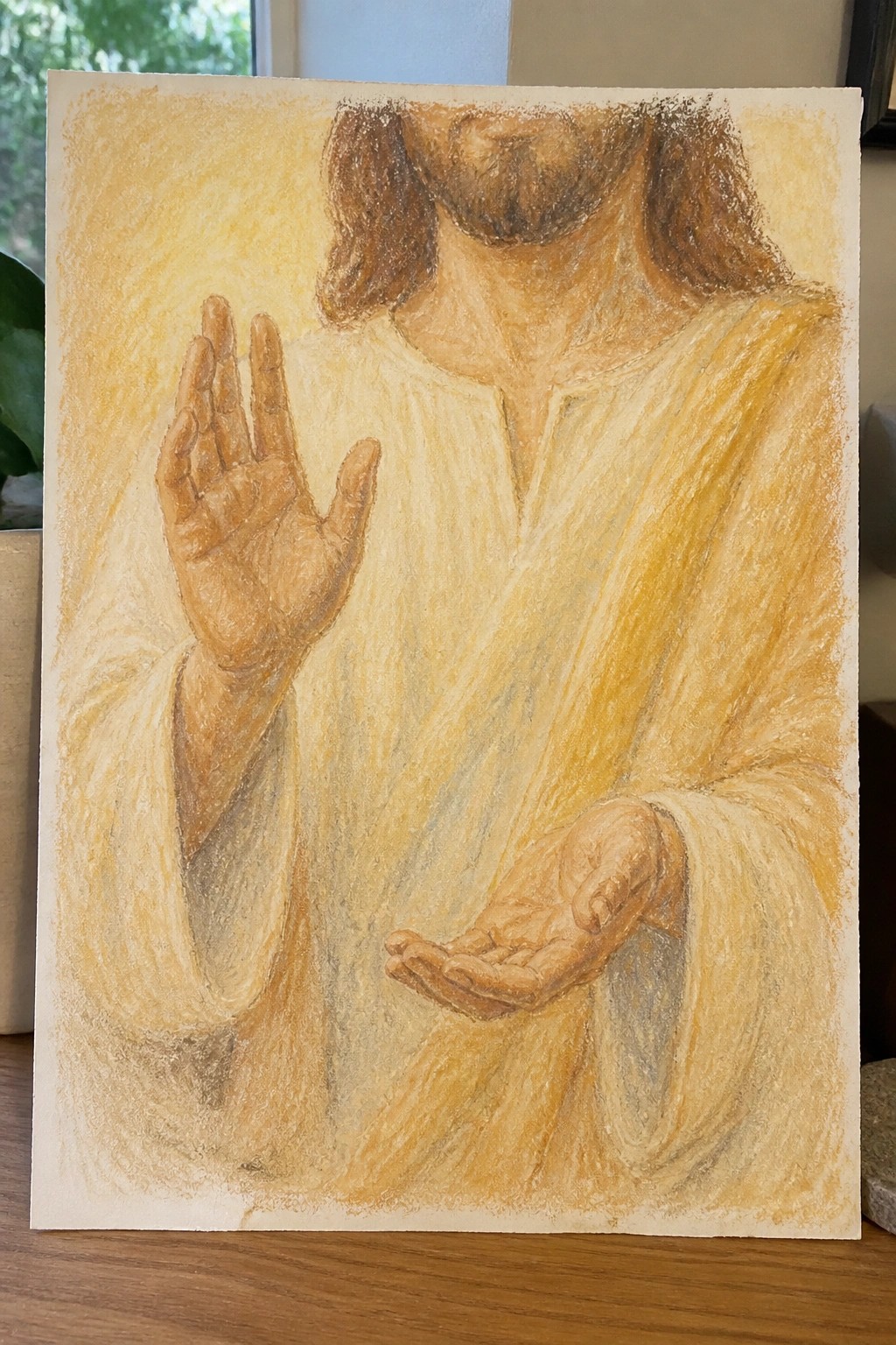 A painting of Jesus with long brown hair and beard, wearing a white robe, one hand raised palm forward and the other held open palm up.