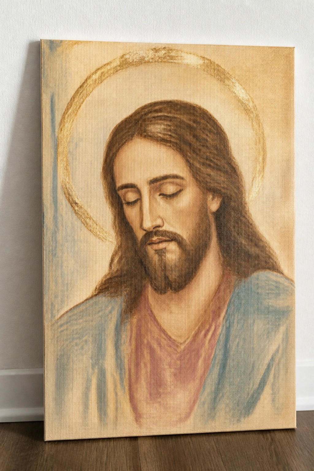 Canvas painting of Jesus with golden halo, closed eyes, long hair and blue robes.