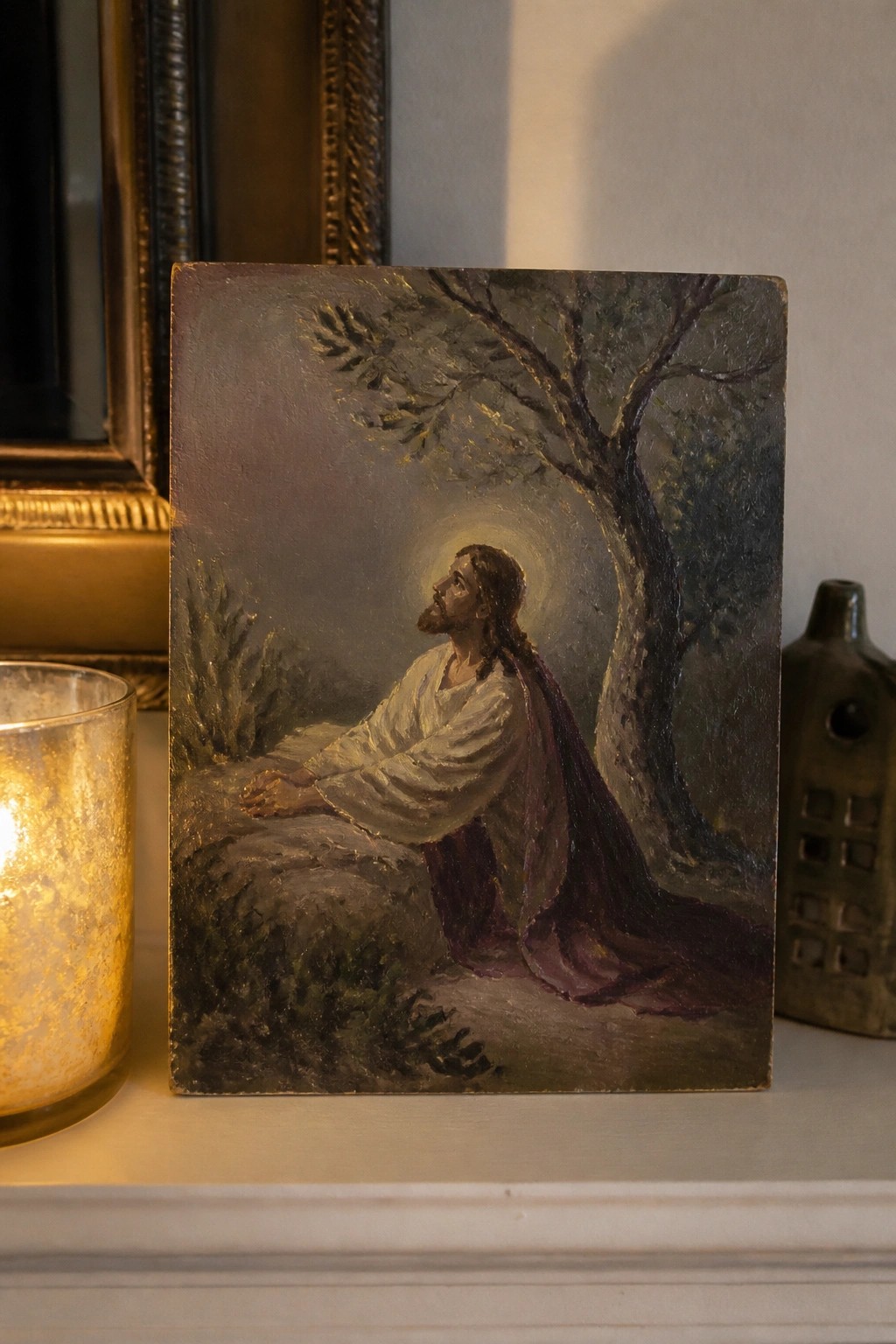 Jesus in white robes with purple sash prays under tree, halo glowing beside lit candle.