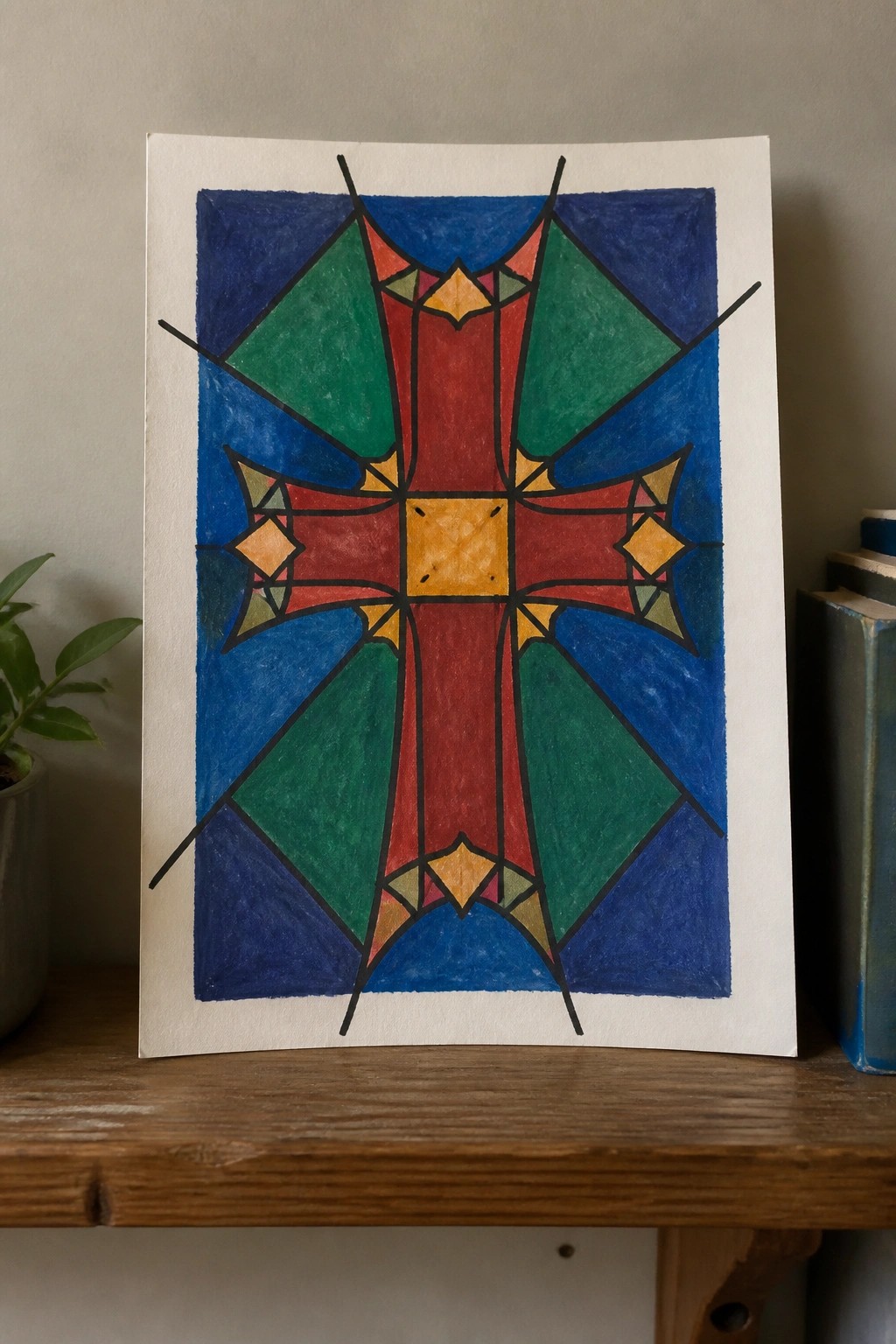 Colorful geometric cross design in red, yellow, green, and blue on wood.