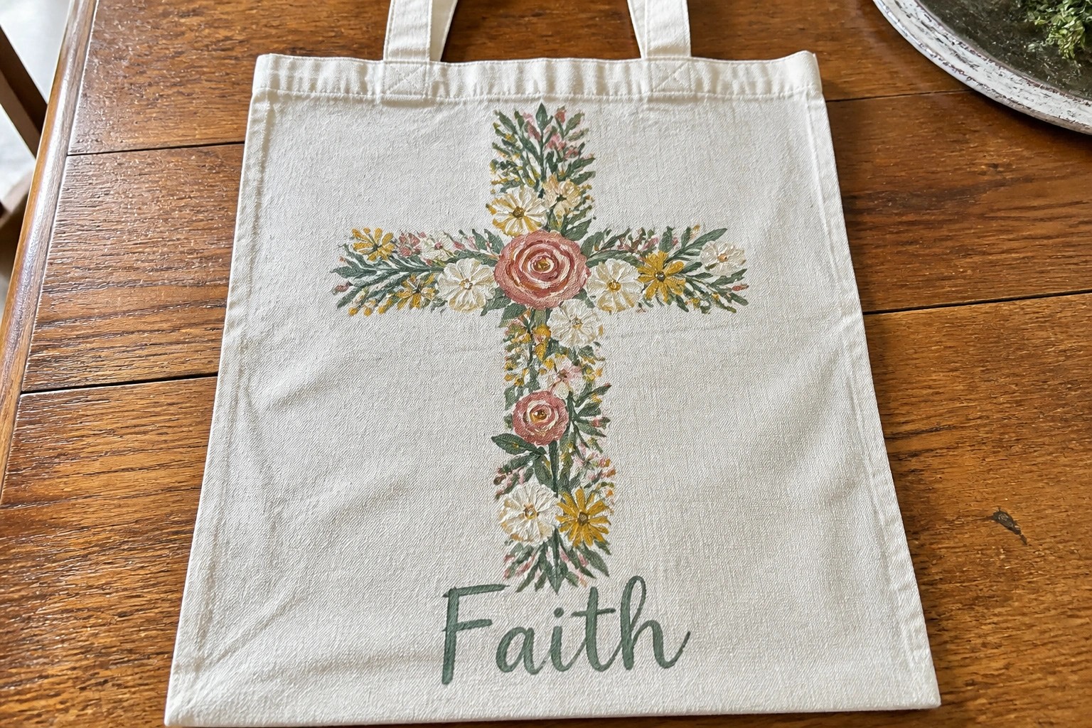 Cream canvas tote bag with floral cross and Faith lettering below