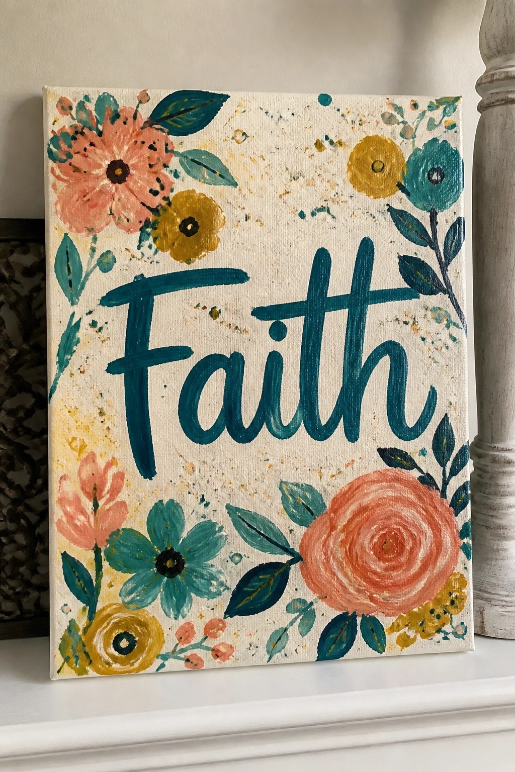 Canvas with Faith in teal cursive amid colorful floral paintings and splatters.