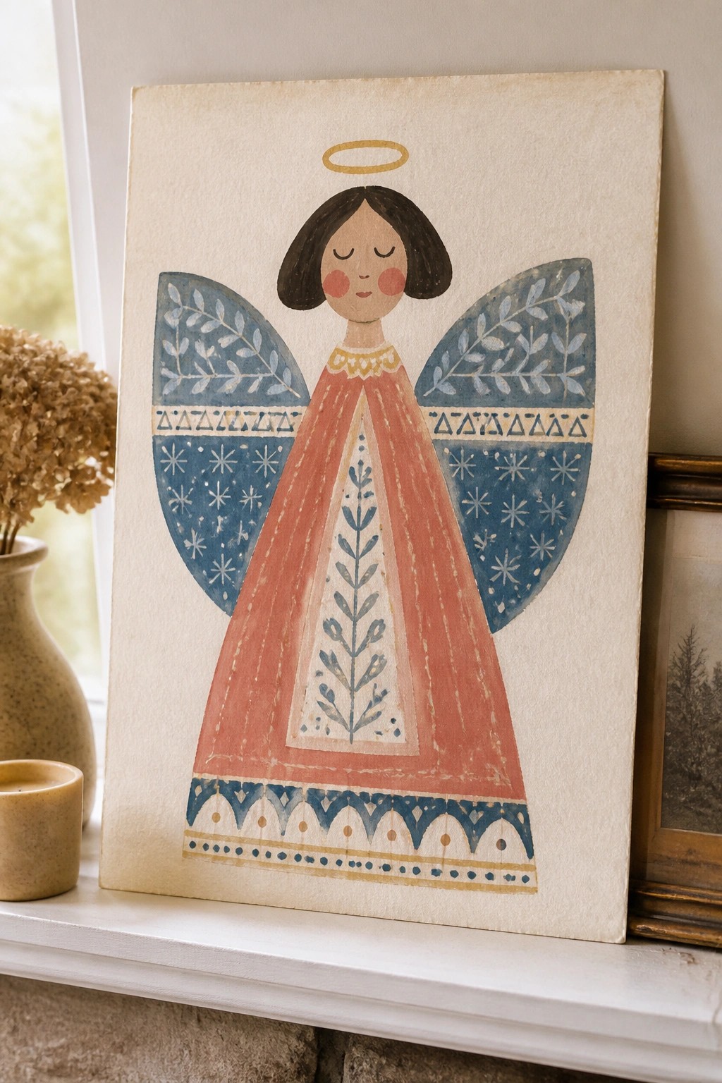 Folk art angel painting with blue patterned wings and coral dress on canvas.
