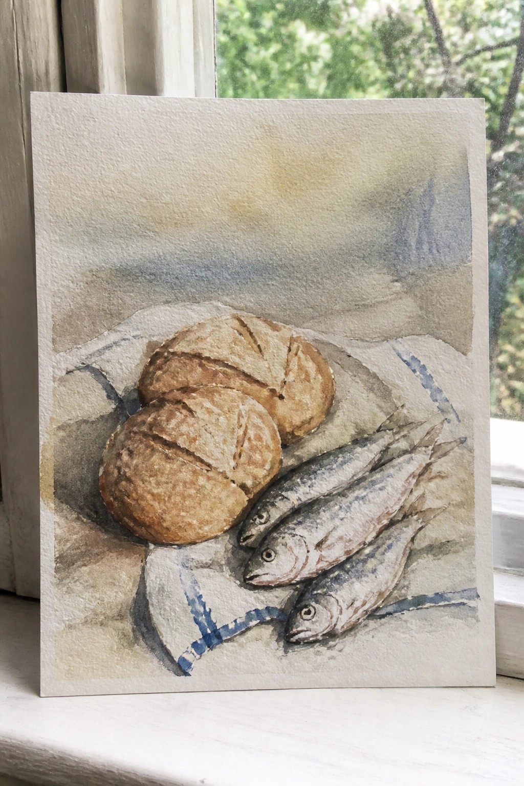Watercolor still life of bread rolls and fish on blue-striped cloth by window