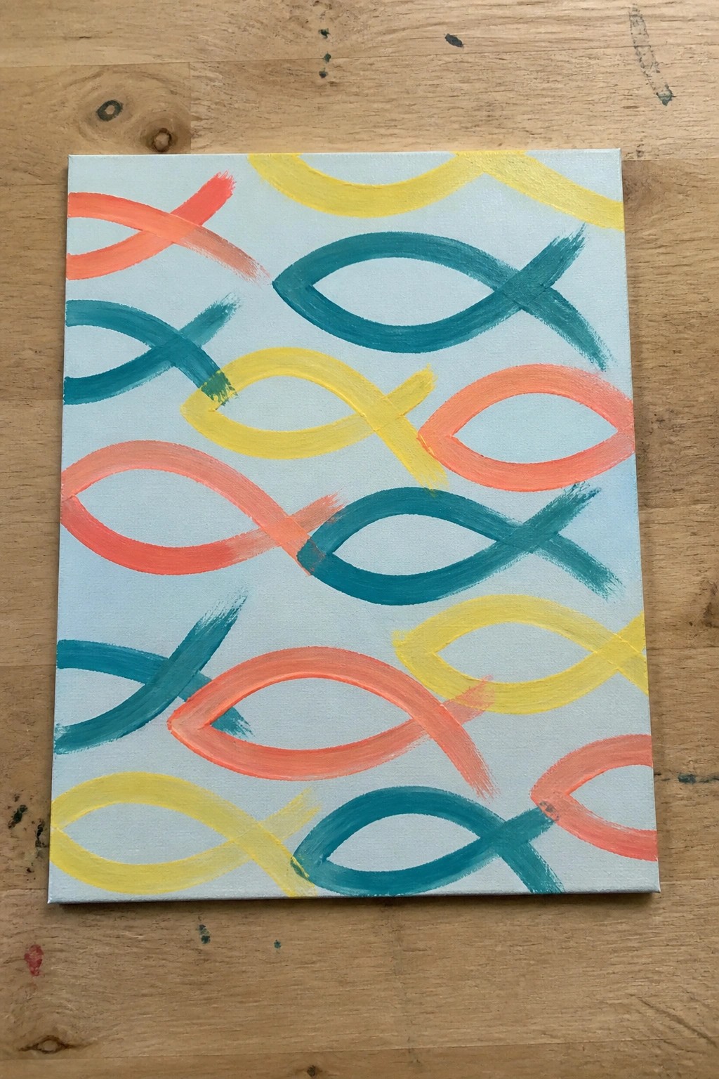 Abstract painting of overlapping orange, teal, and yellow loops on light blue canvas